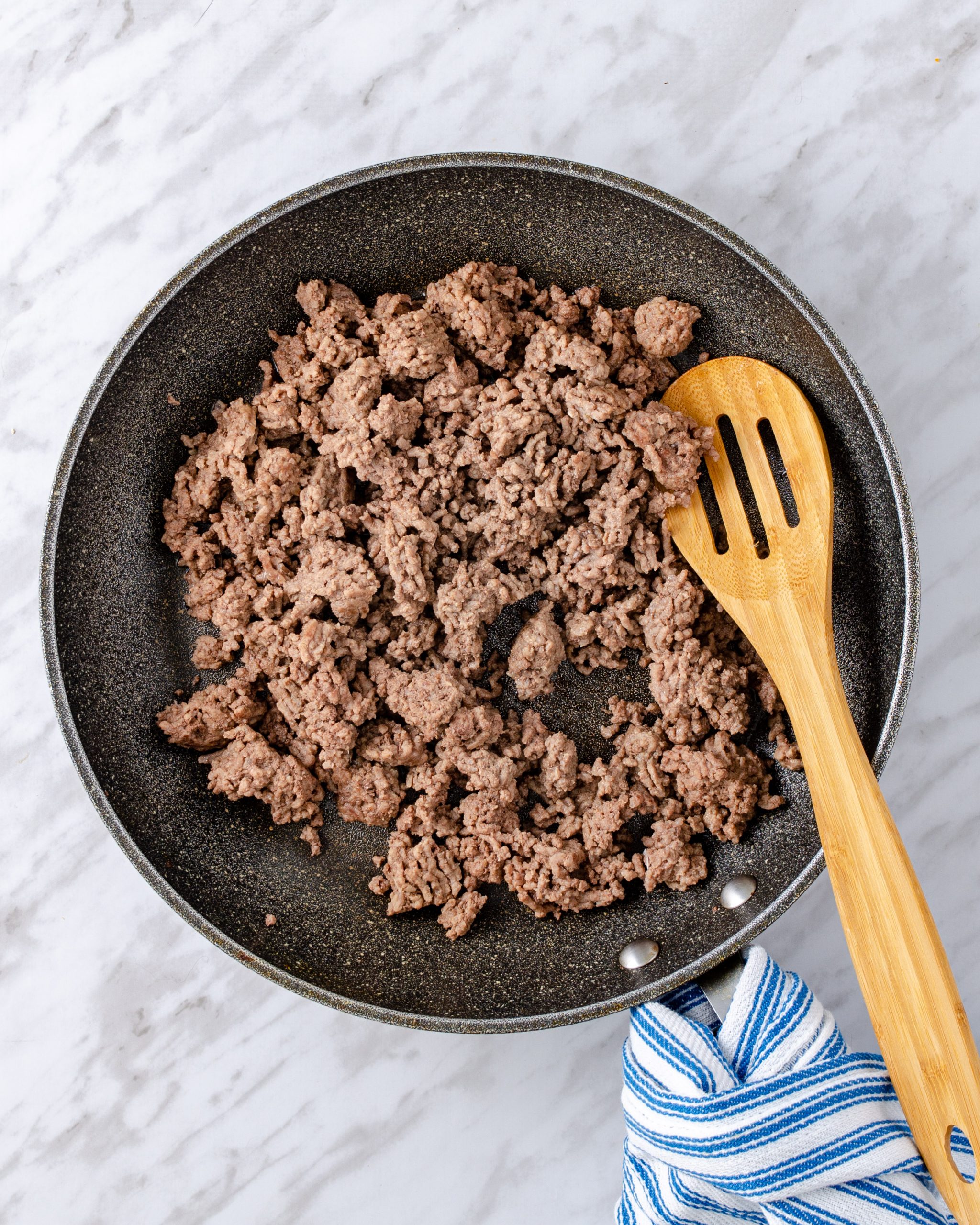 In a large skillet over medium heat, add the ground beef seasoned with salt and pepper and cook until brown.
