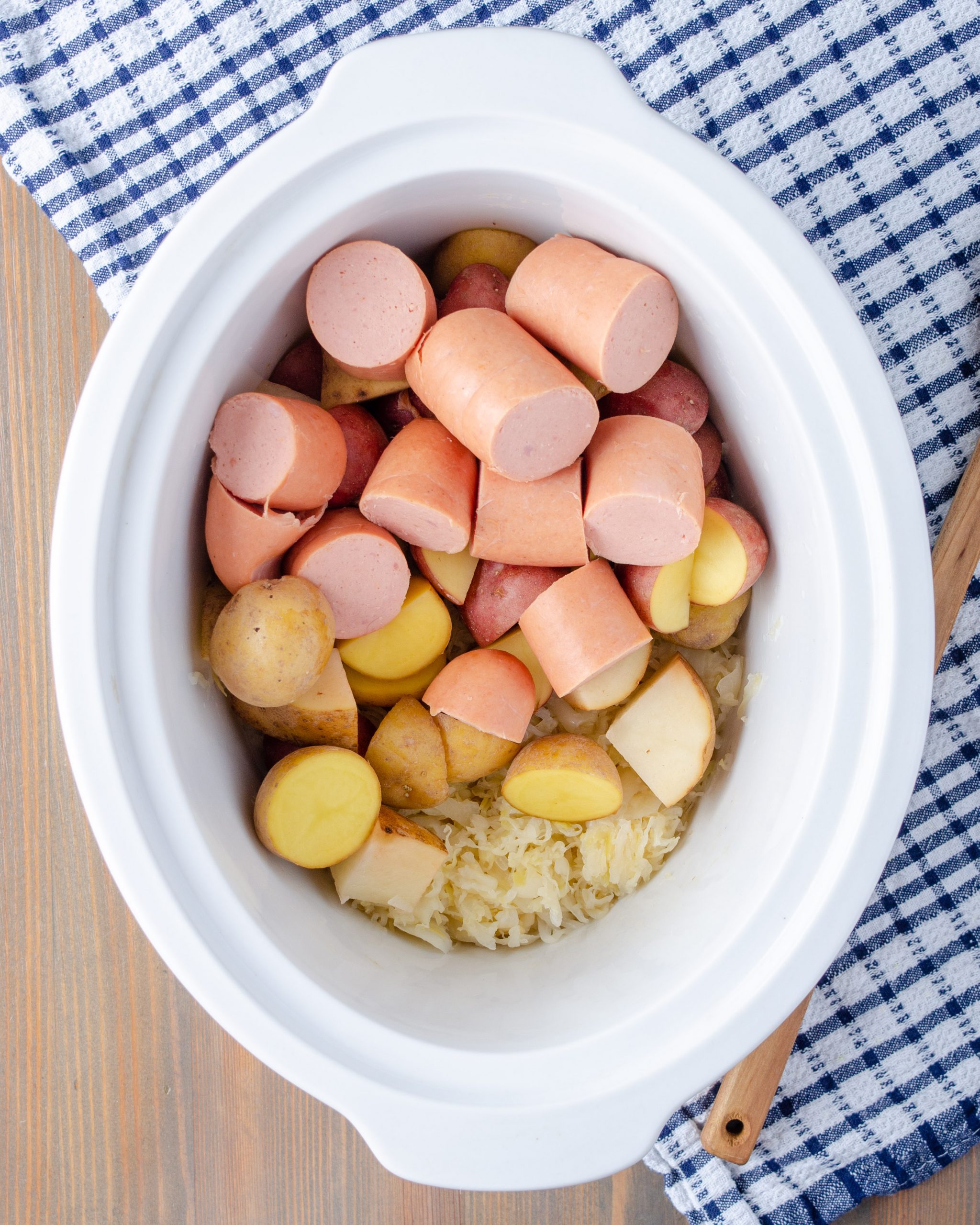 Cover the sauerkraut with the potatoes and then the sausage.