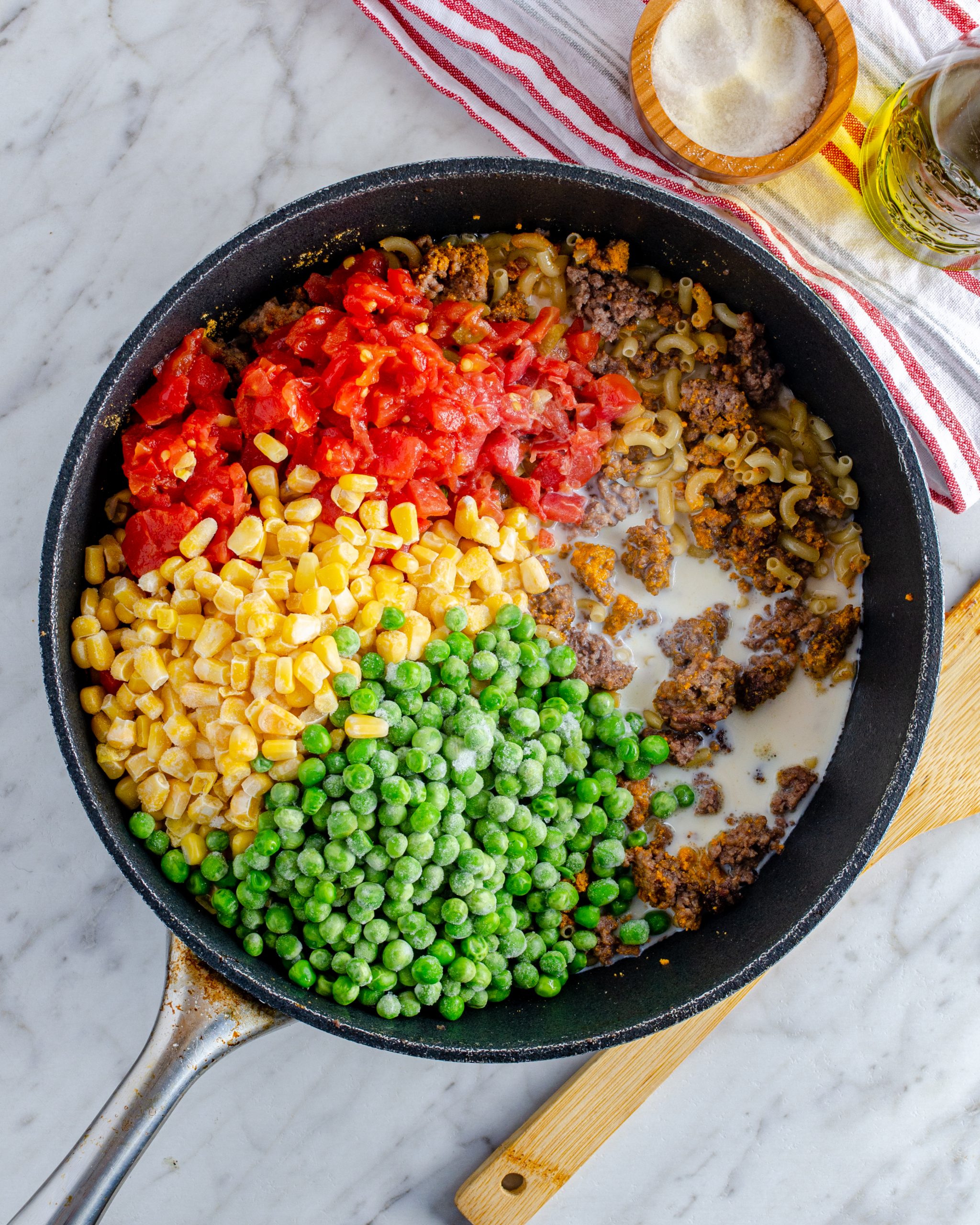 Place the tomatoes, milk, frozen corn, frozen peas, and salt to taste.
