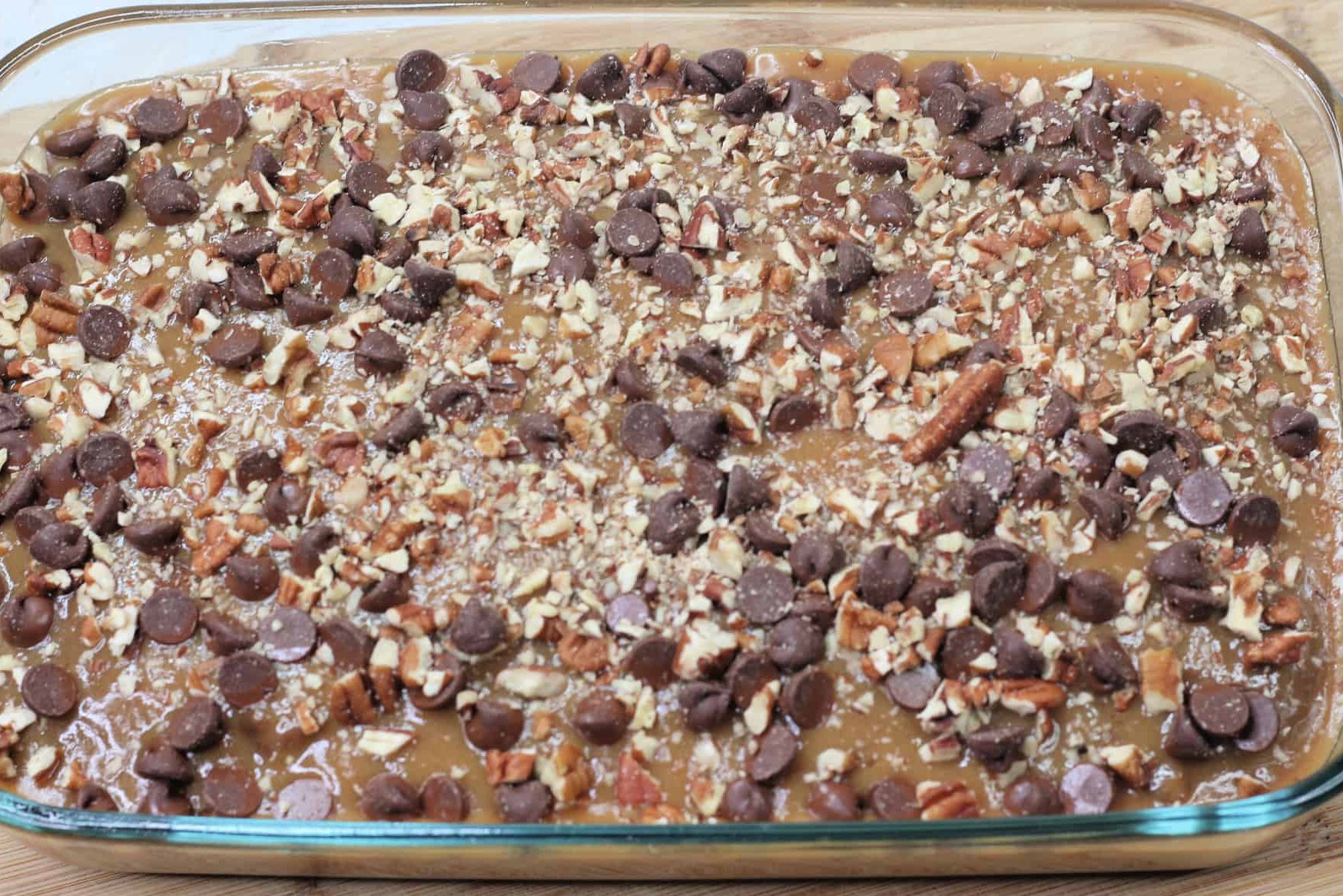 Sprinkle the chocolate chips and pecans over the caramel topping and cake.