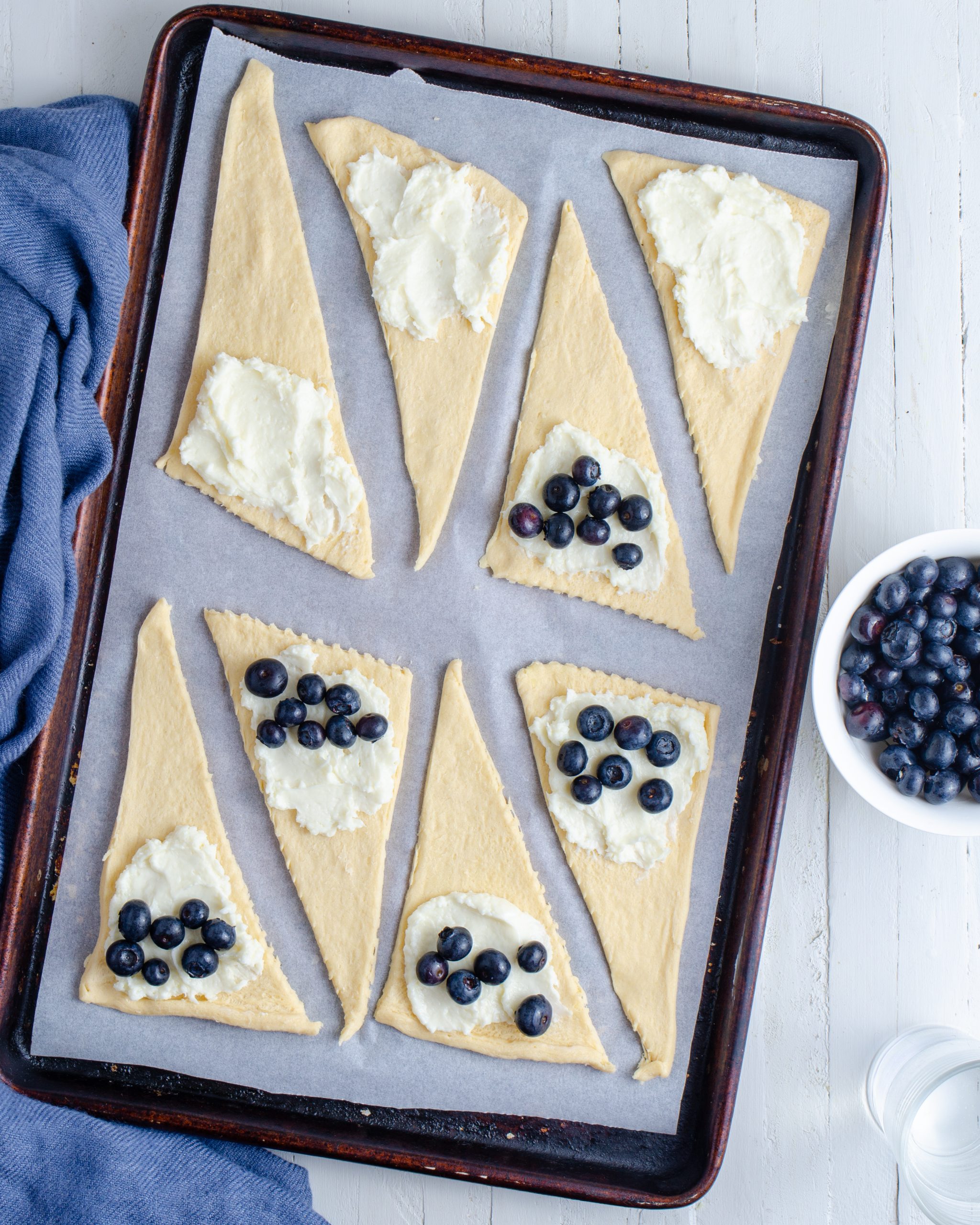 Add a teaspoon of the filling mixture to the wider end of each crescent roll along with some of the fresh blueberries. 