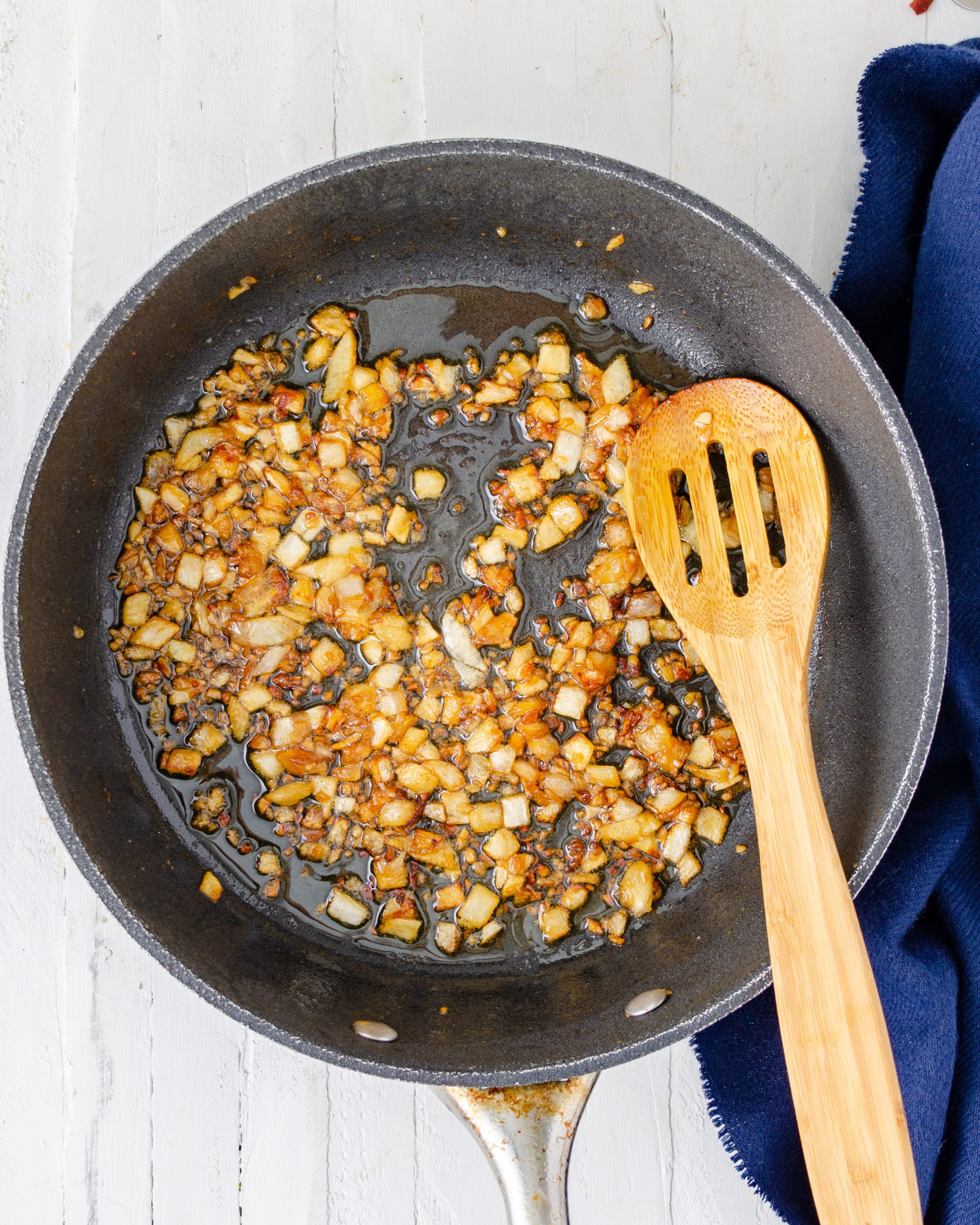 Add the olive oil to the same skillet over medium heat, and saute the onion and garlic until the onion has become tender.
