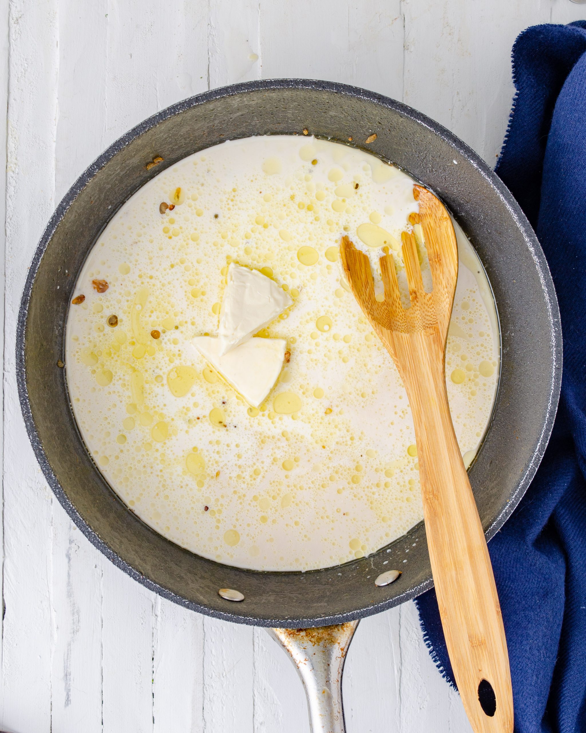 Stir the cheese wedges into the skillet until melted, and then pour in the half and half and chicken broth. Whisk to combine well.