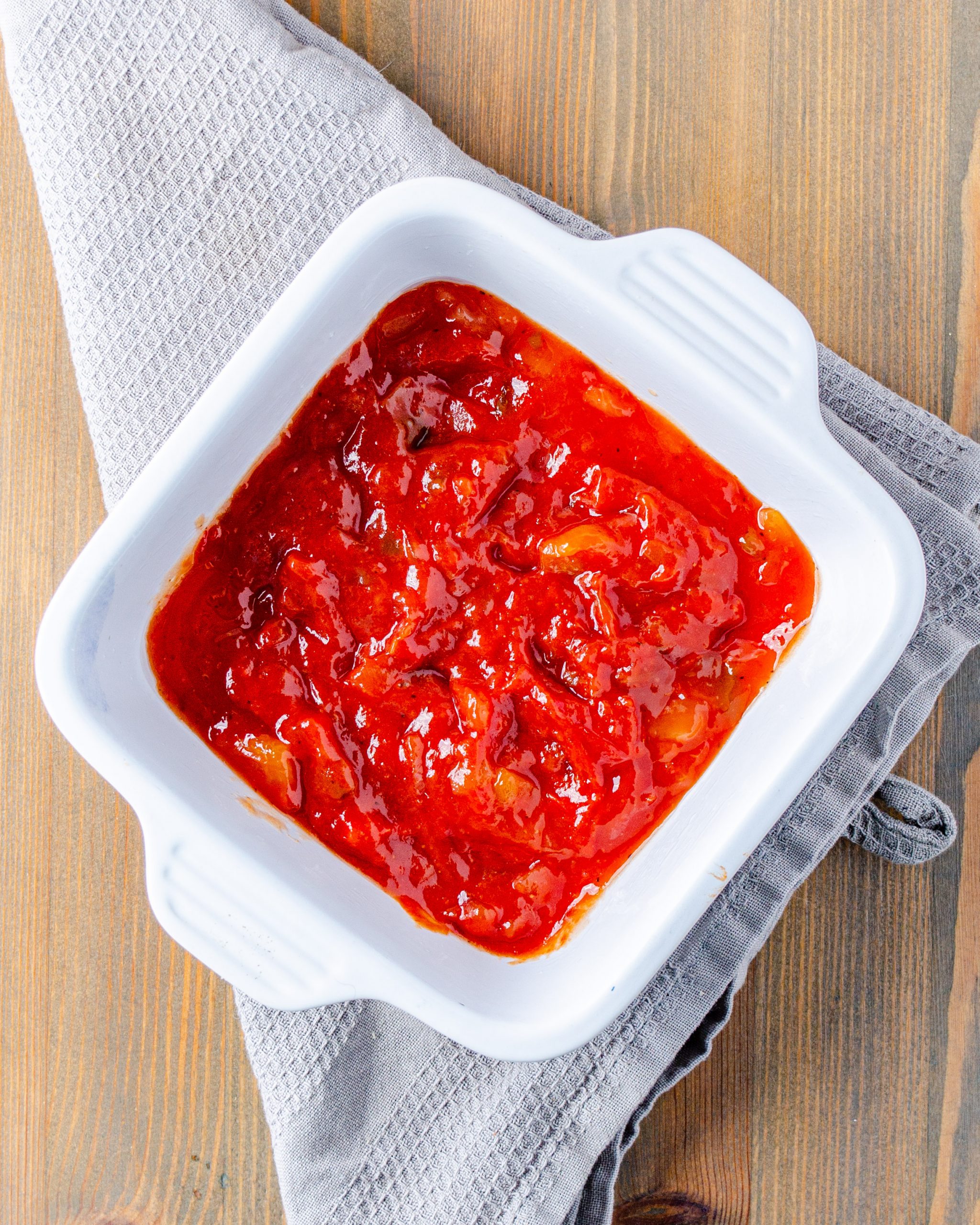 Place the chili sauce into a microwave-safe bowl and cook until hot. Place the sauce into an even layer on the bottom of a 9x9 baking dish.