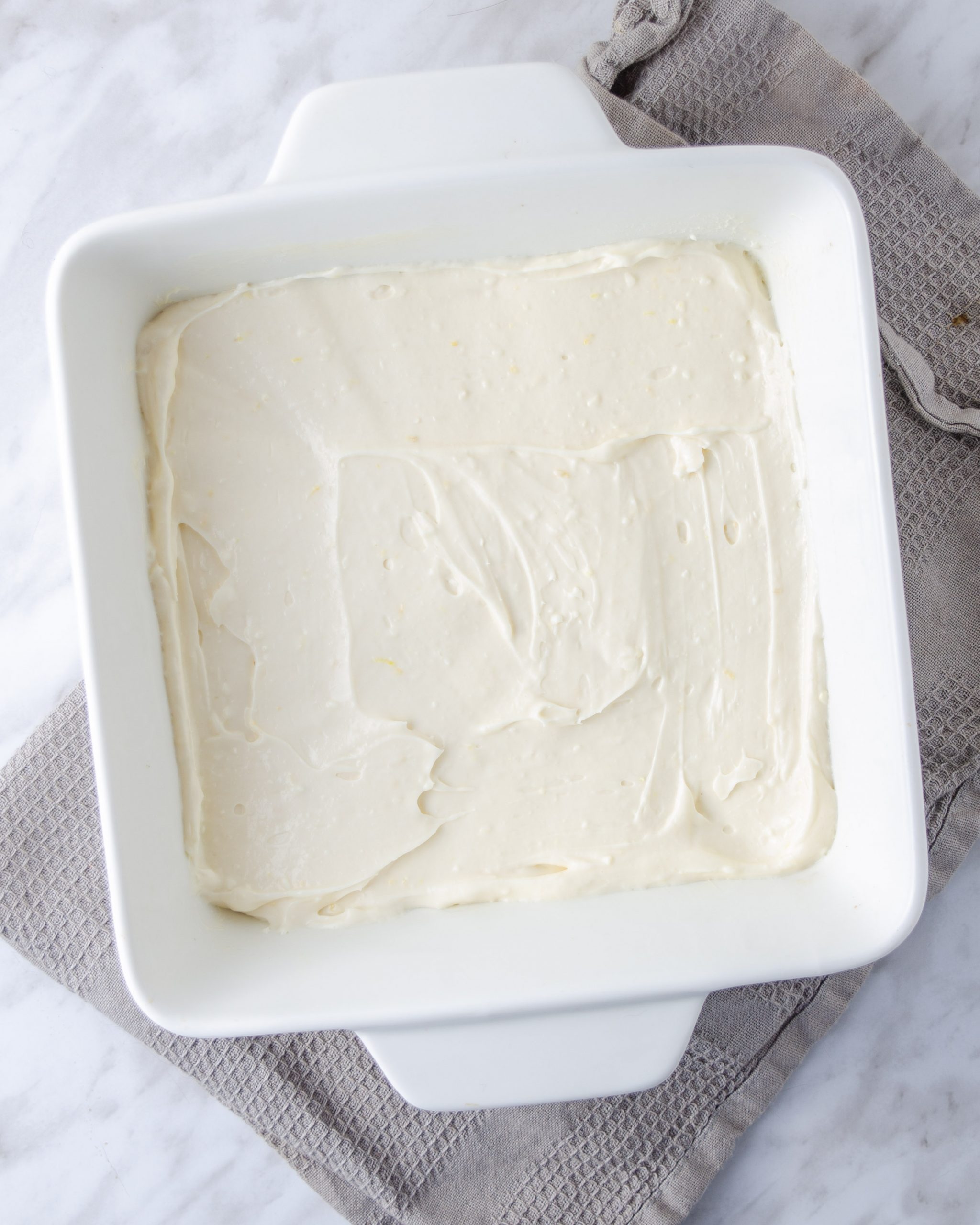 Spread the cream cheese mixture over the layer of dough in the baking dish.