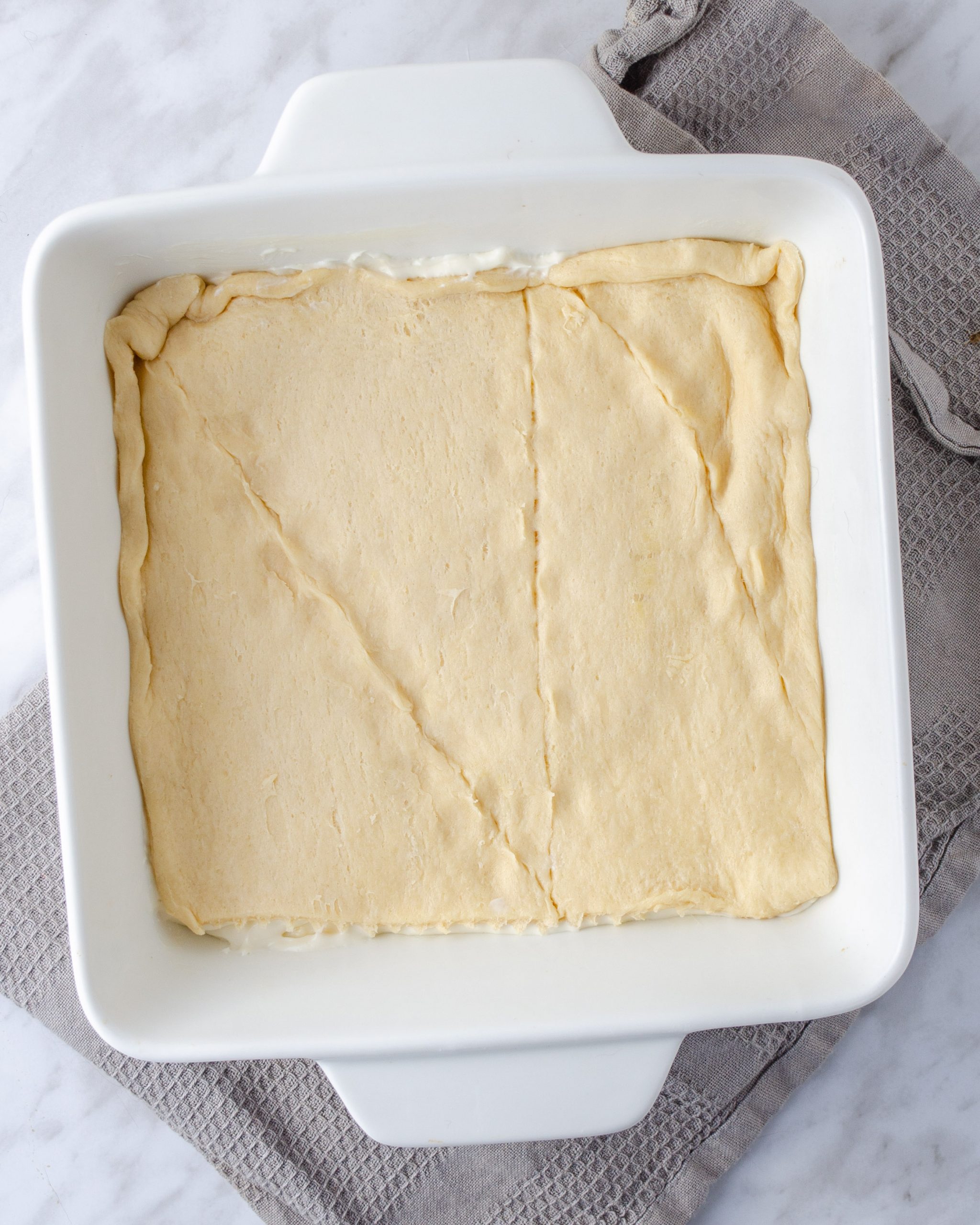 Top the filling with the remaining layer of dough.
