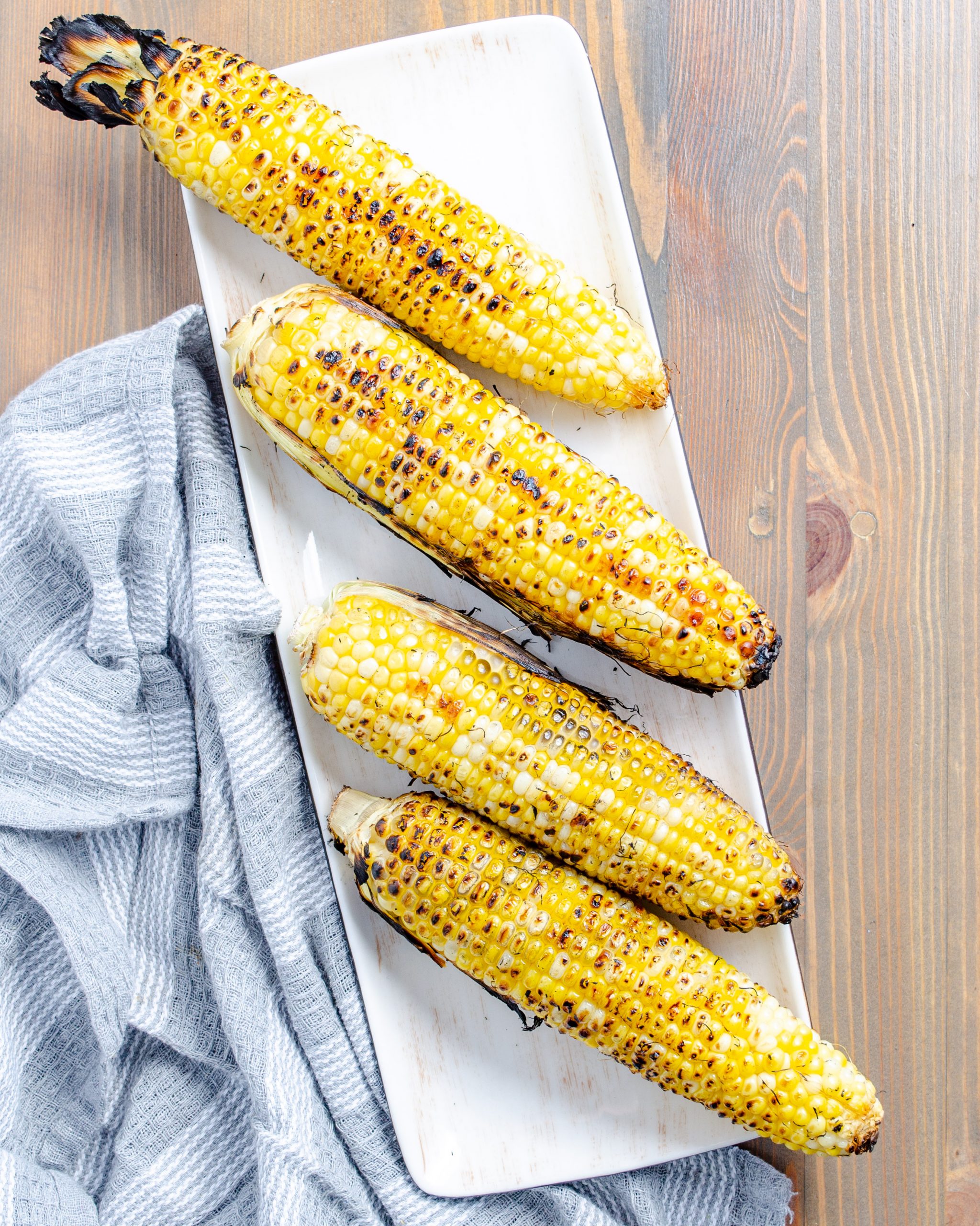 Preheat the grill to 400˚F. Place ears of corn until grilled for about 12 minutes, turning around every few minutes to ensure even grilling on each side.