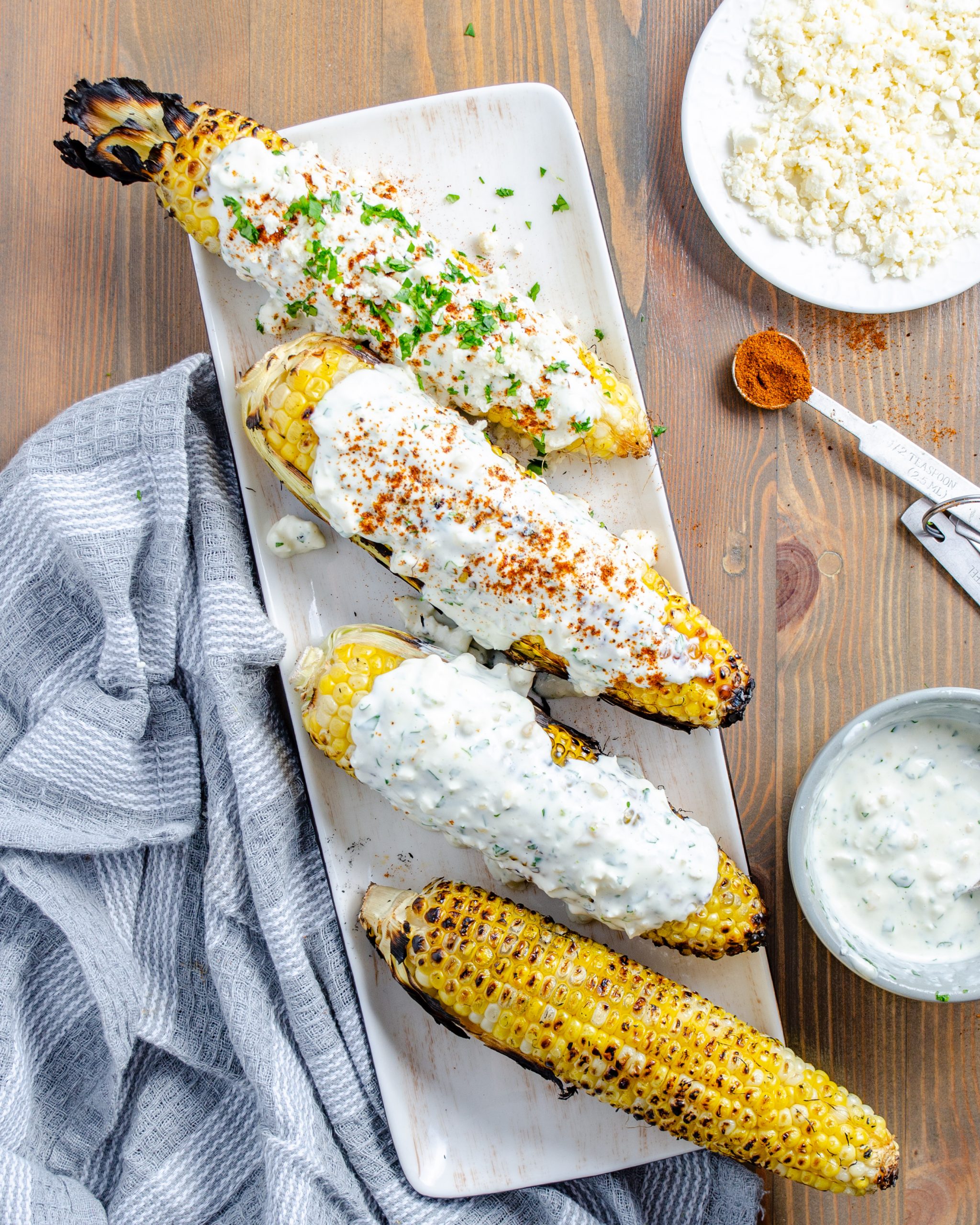 Spread mixture evenly over each ear of corn, then sprinkle with chipotle chili powder. Top with extra cotija cheese and chopped cilantro and serve.