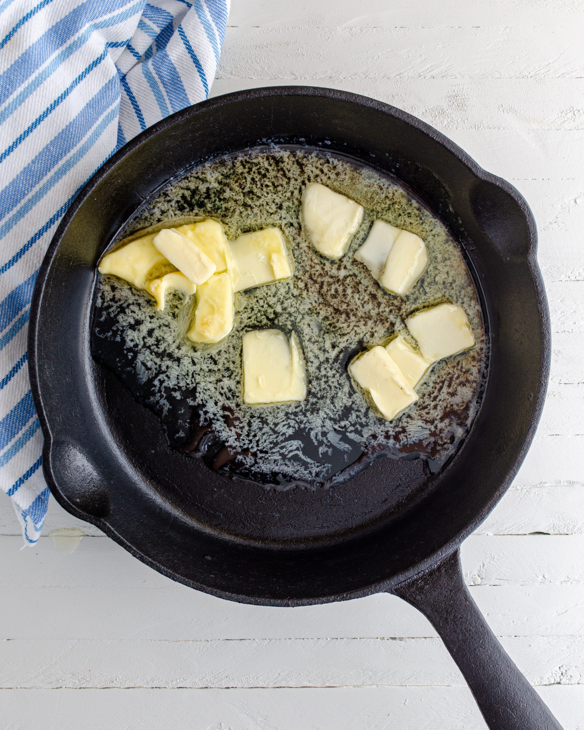 Place the butter into an oven safe skillet on the stove, and melt it over medium heat.