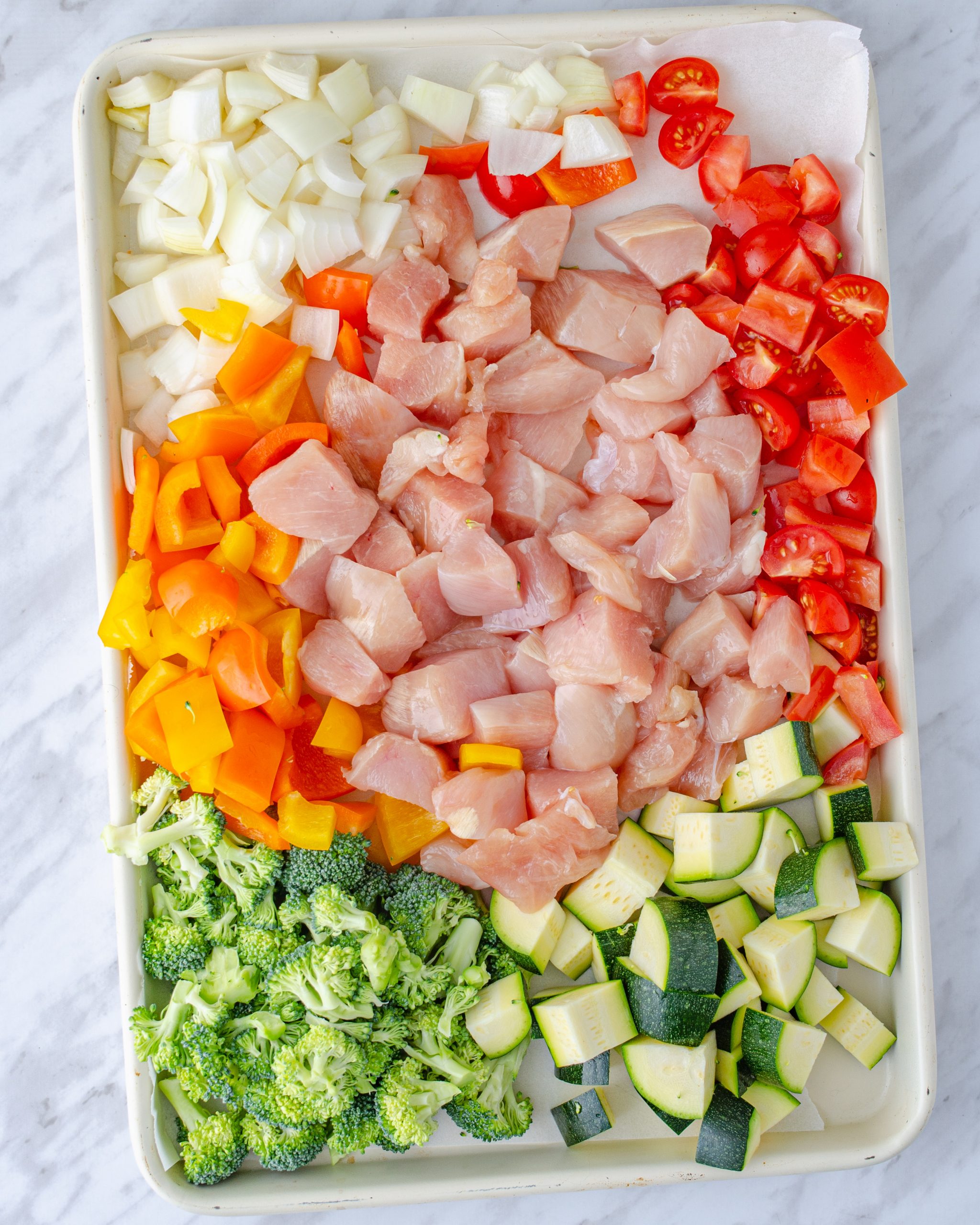 Add the chicken and vegetables to the baking sheet.