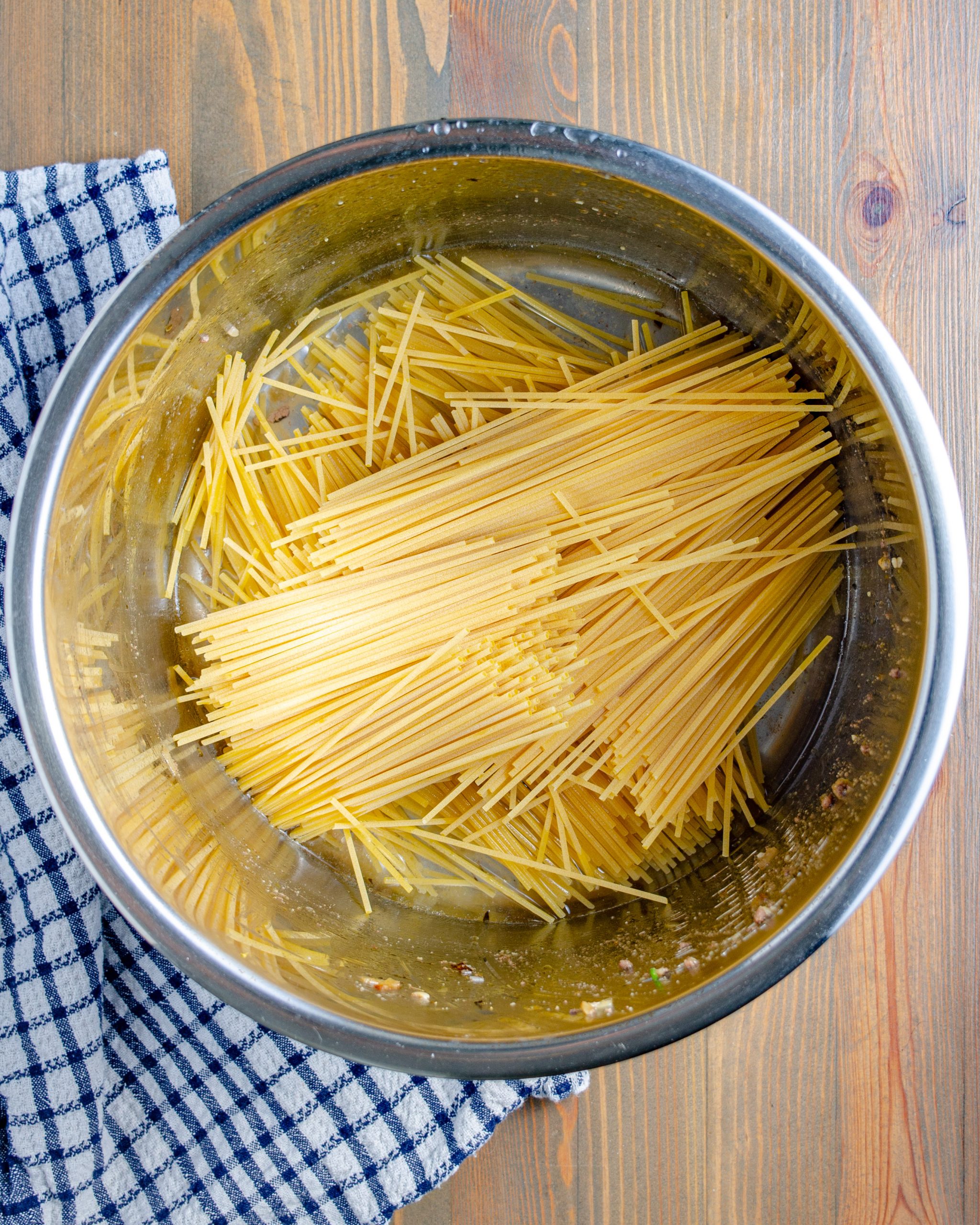 Break the spaghetti noodles in half, and layer them in an “x” pattern in the bottom of the pot.