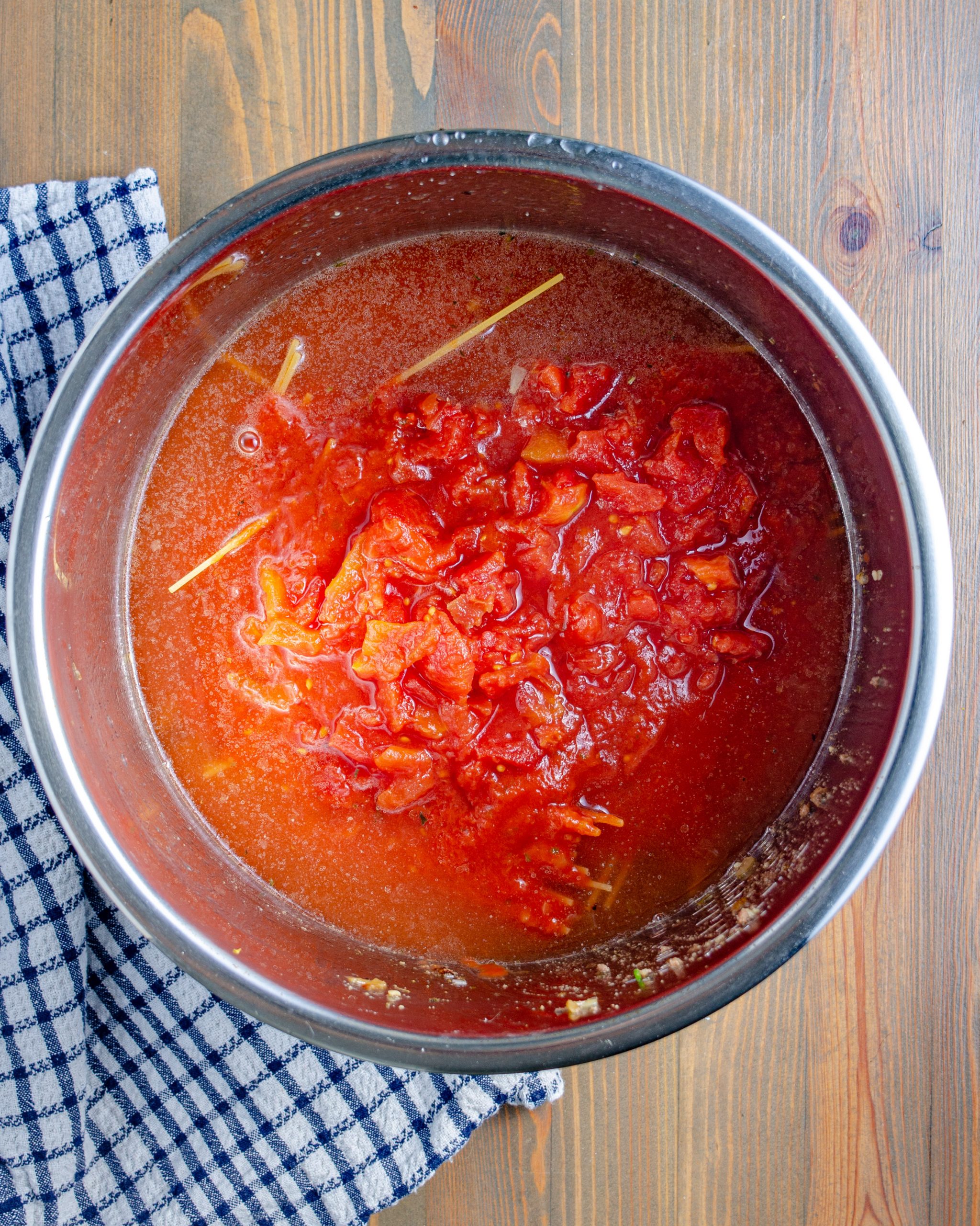 Cover the spaghetti noodles completely with the pasta sauce, diced tomatoes and remaining water. Be sure the noodles are submerged completely. 