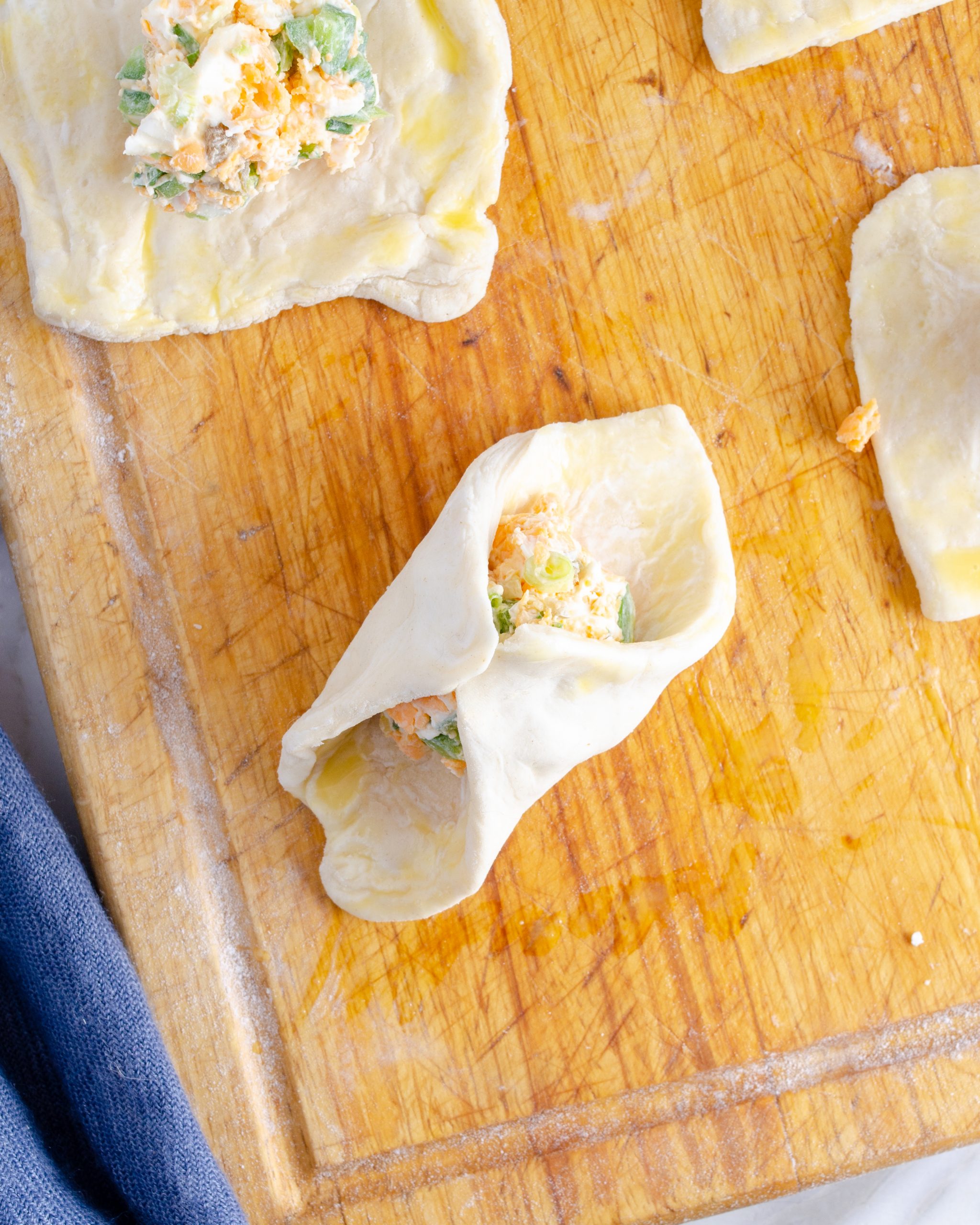 Fold up all four corners of the puff pastry square around the filling.
