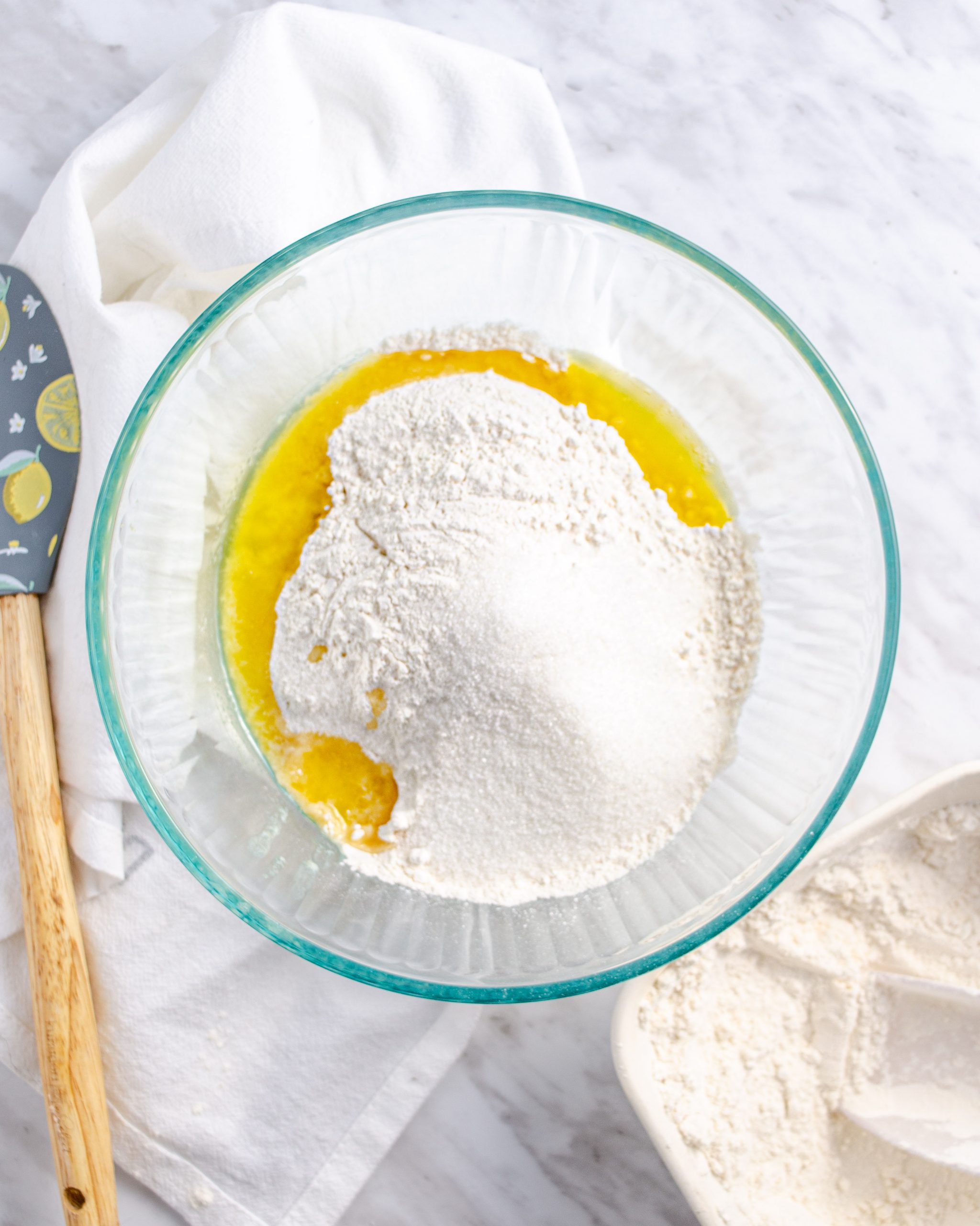 In a separate bowl, combine the melted butter, 2 ¾ cups of flour, and the remaining sugar.