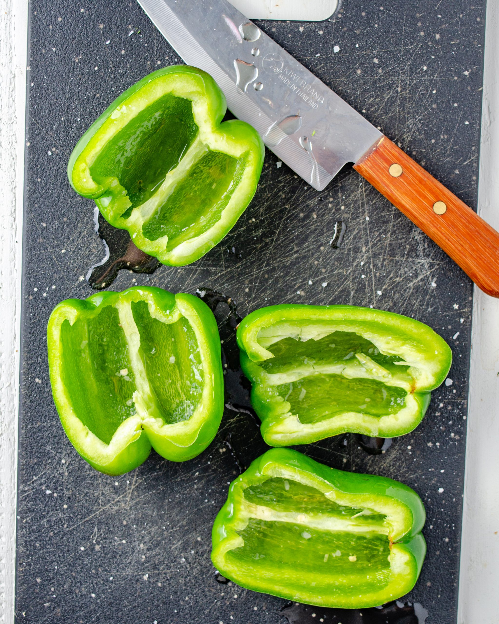 Remove the seeds from 4 green bell peppers and cut them in half lengthwise.