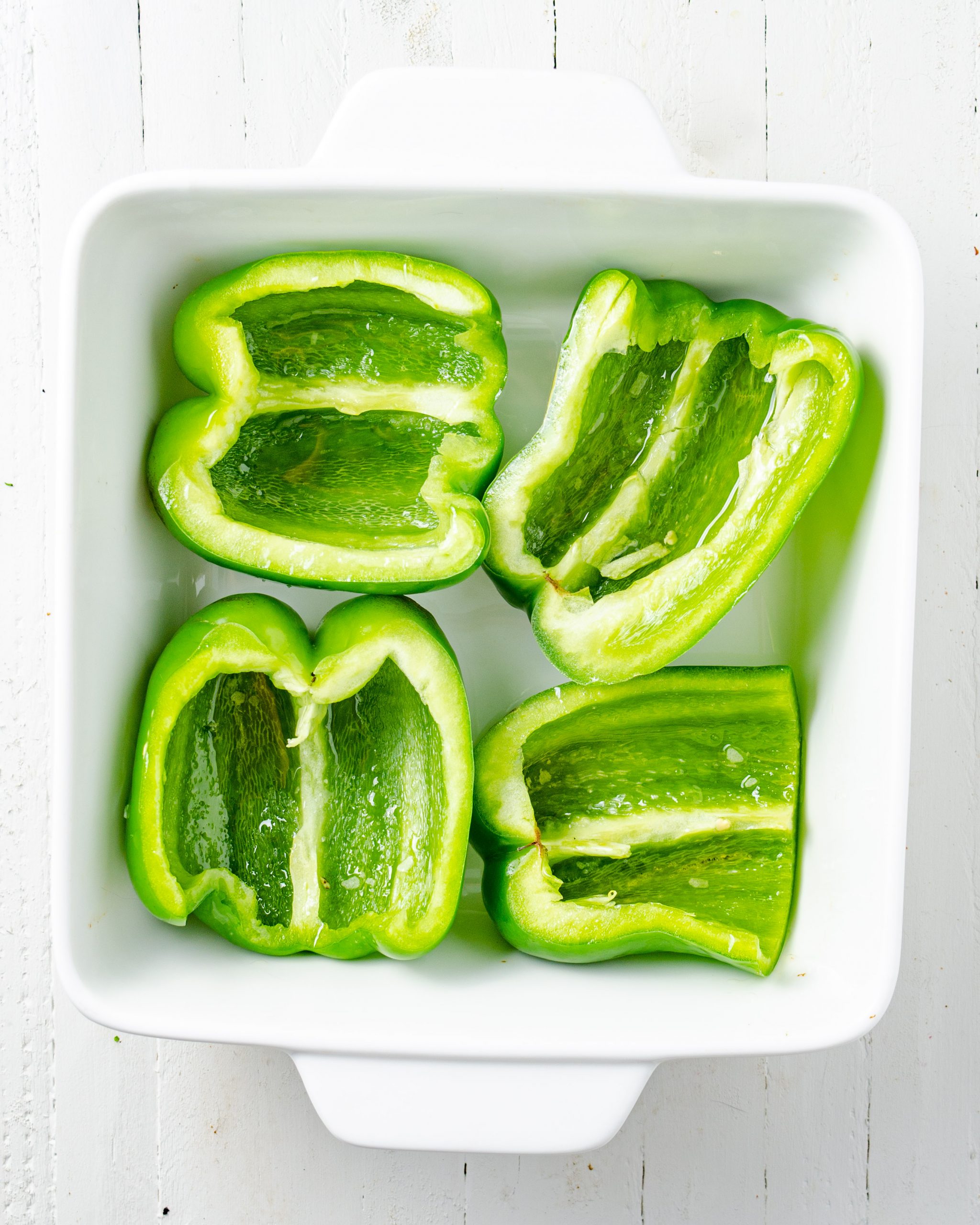 Place the cut green peppers into a 9x13 baking dish, and drizzle with 1 Tbsp of olive oil. 