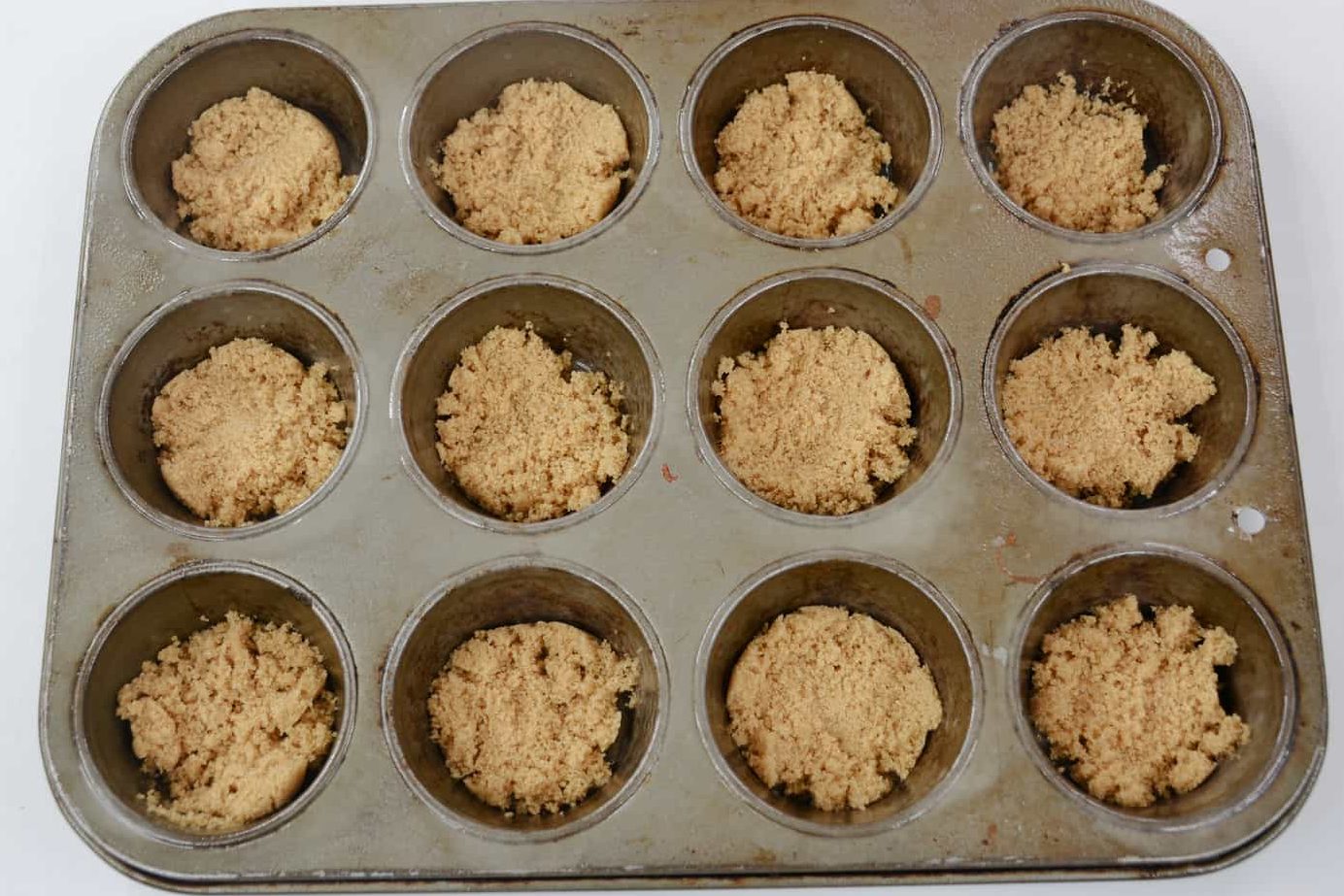 Add one teaspoon of melted butter in each of the muffin cups,