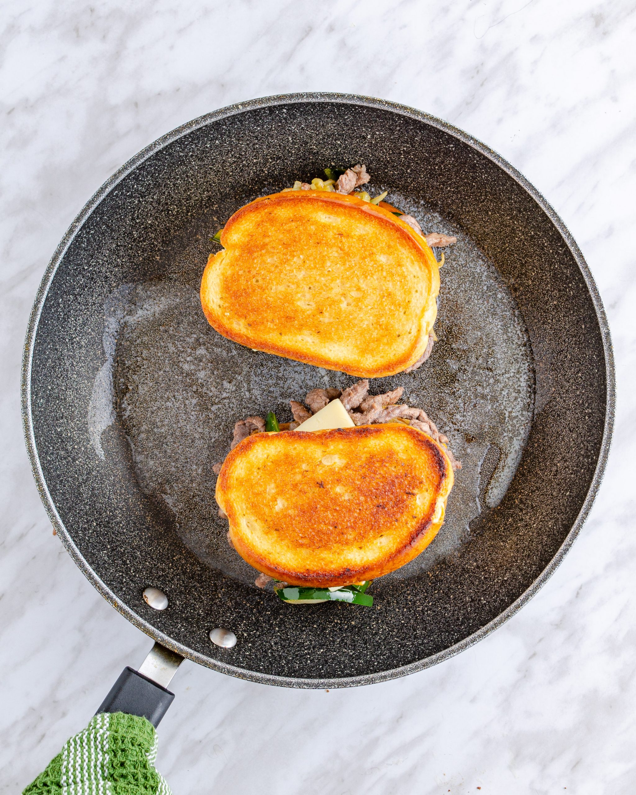 Place the sandwiches into the skillet, cooking for several minutes on top until the bread is toasted and the cheese has melted.