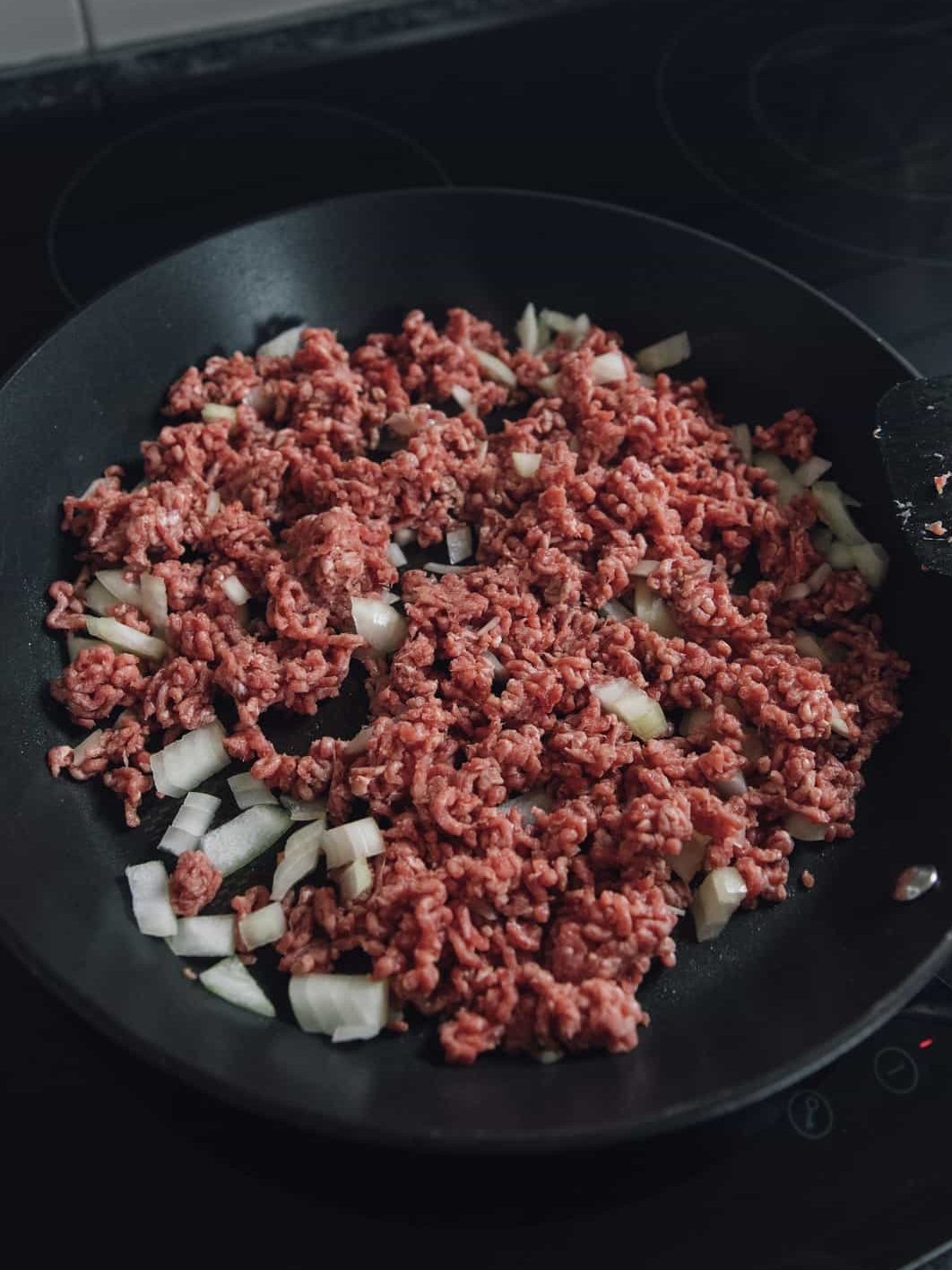 In a large skillet over medium heat, add the ground beef and diced onion. Brown meat until thoroughly cooked. Drain off excess fat and return to skillet.