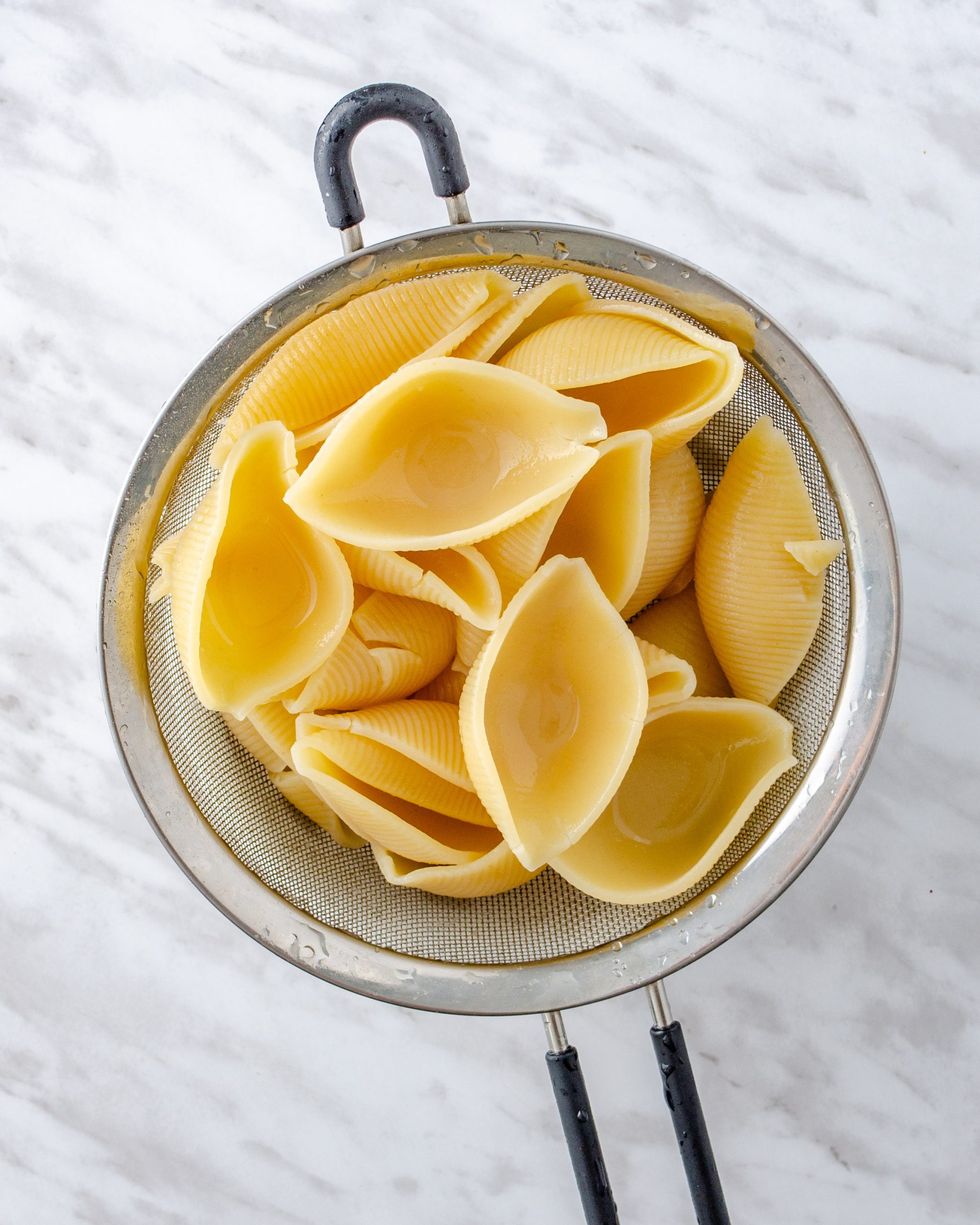 Boil the jumbo shell pasta until al dente, drain, and rinse in cold water to keep the noodles from sticking together.