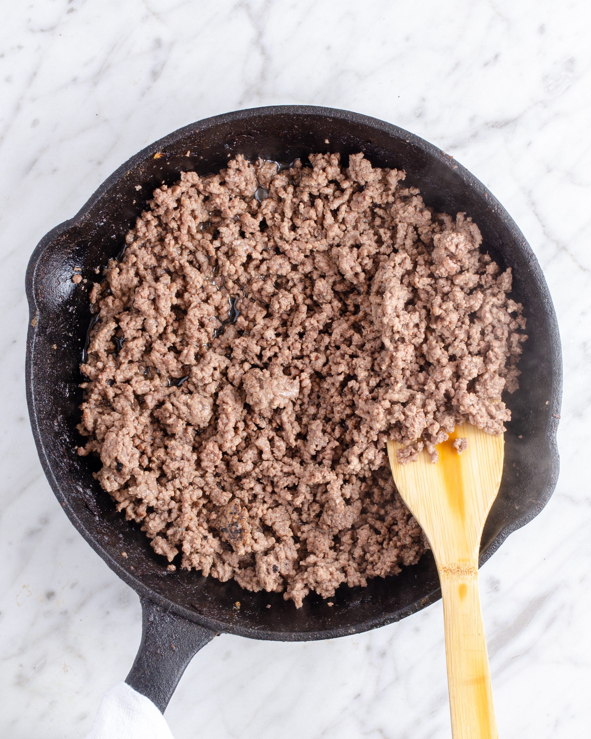 Brown the ground beef in a skillet over medium-high heat, and drain the excess grease. 