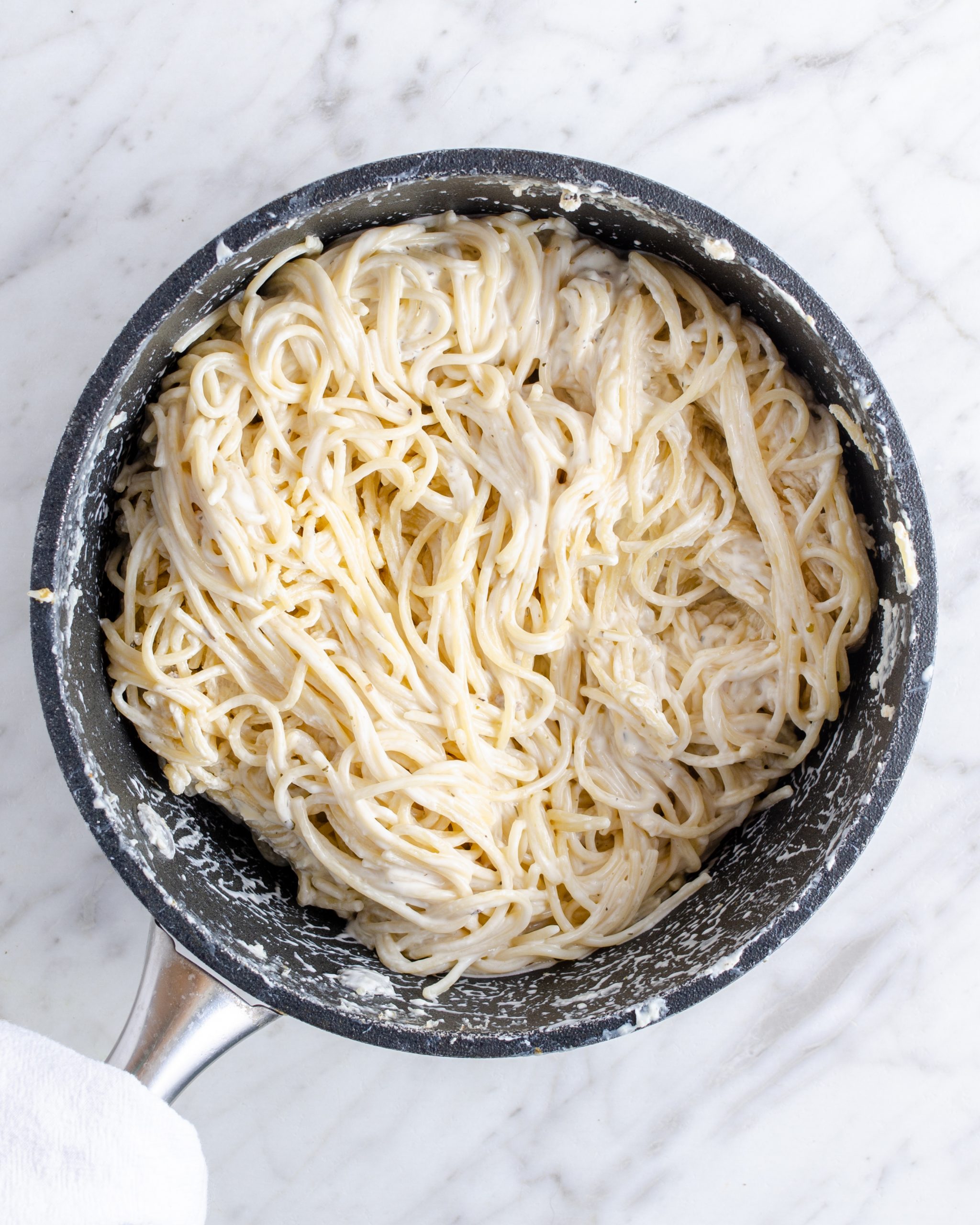 Add the hot spaghetti to a large mixing bowl with the cream cheese, minced garlic, garlic salt, and Italian seasoning. Stir to combine until the cheese has melted