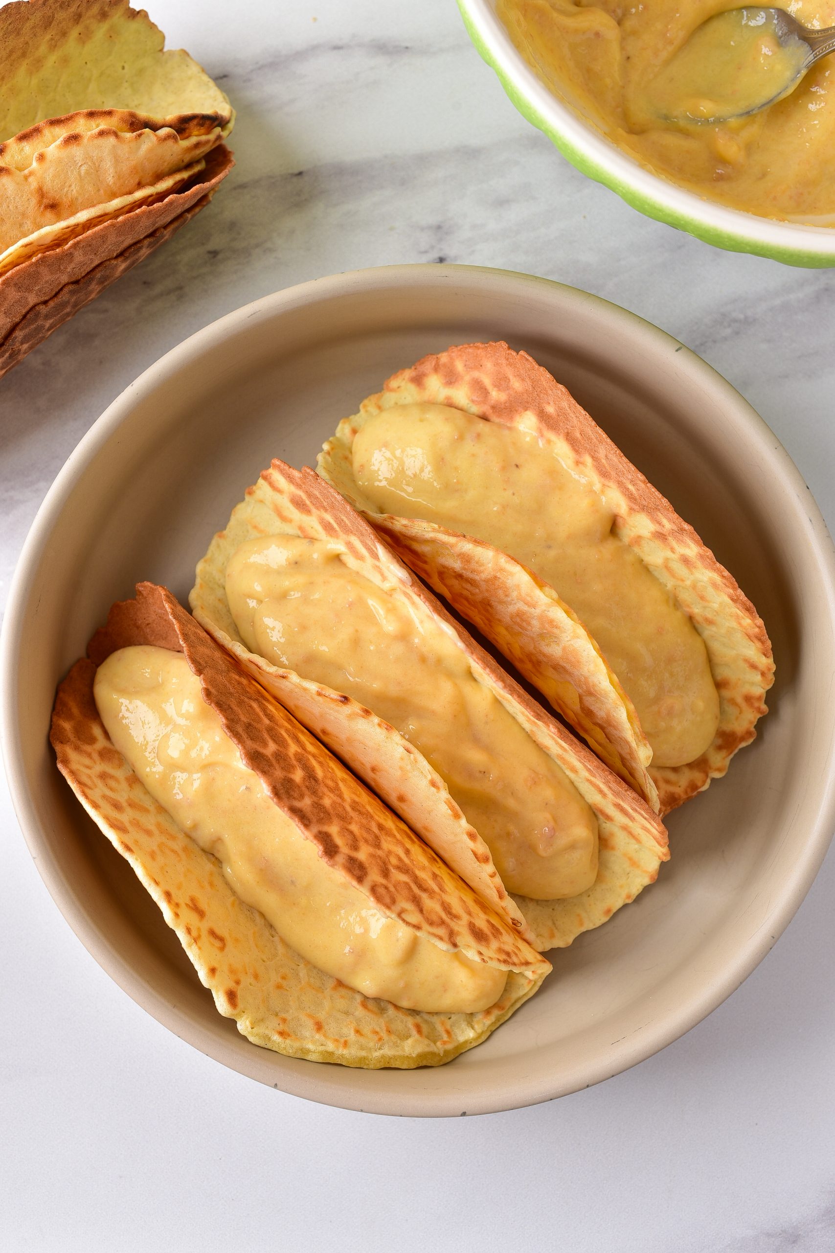 Place a layer of wafers into the bottom of each taco shell, and top with an equal amount of the pudding mixture.