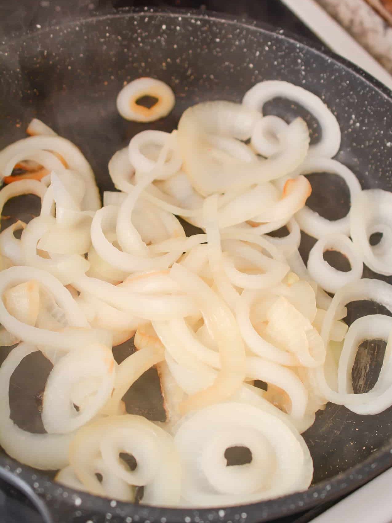 Add the onions to a skillet over medium heat on the stove, and add just enough salt to have them start releasing moisture from them. Saute until tender and caramelized then set aside.