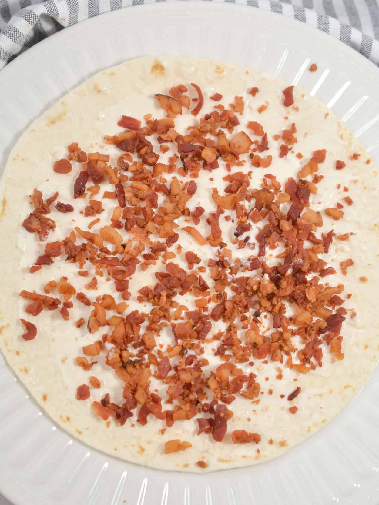 Top the tortillas with ⅓ cup bacon chopped.