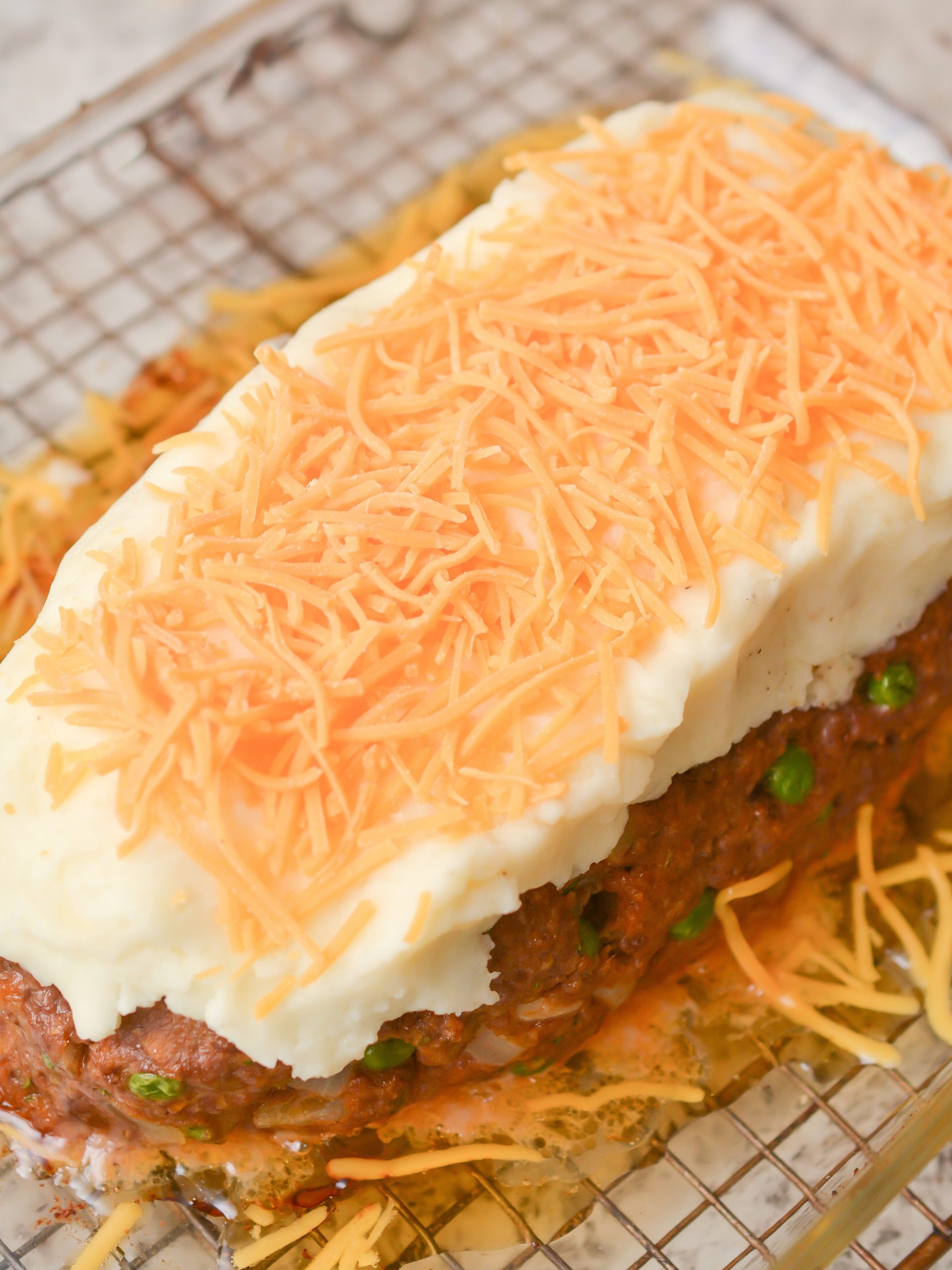 Spread the mashed potatoes on the meatloaf, and top with the cheese. 