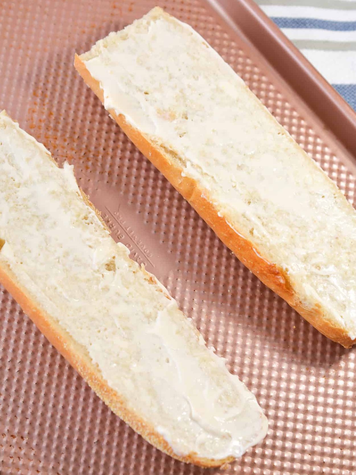 Place the sliced bread open side up on a baking sheet and add a layer of mayonnaise to the top.