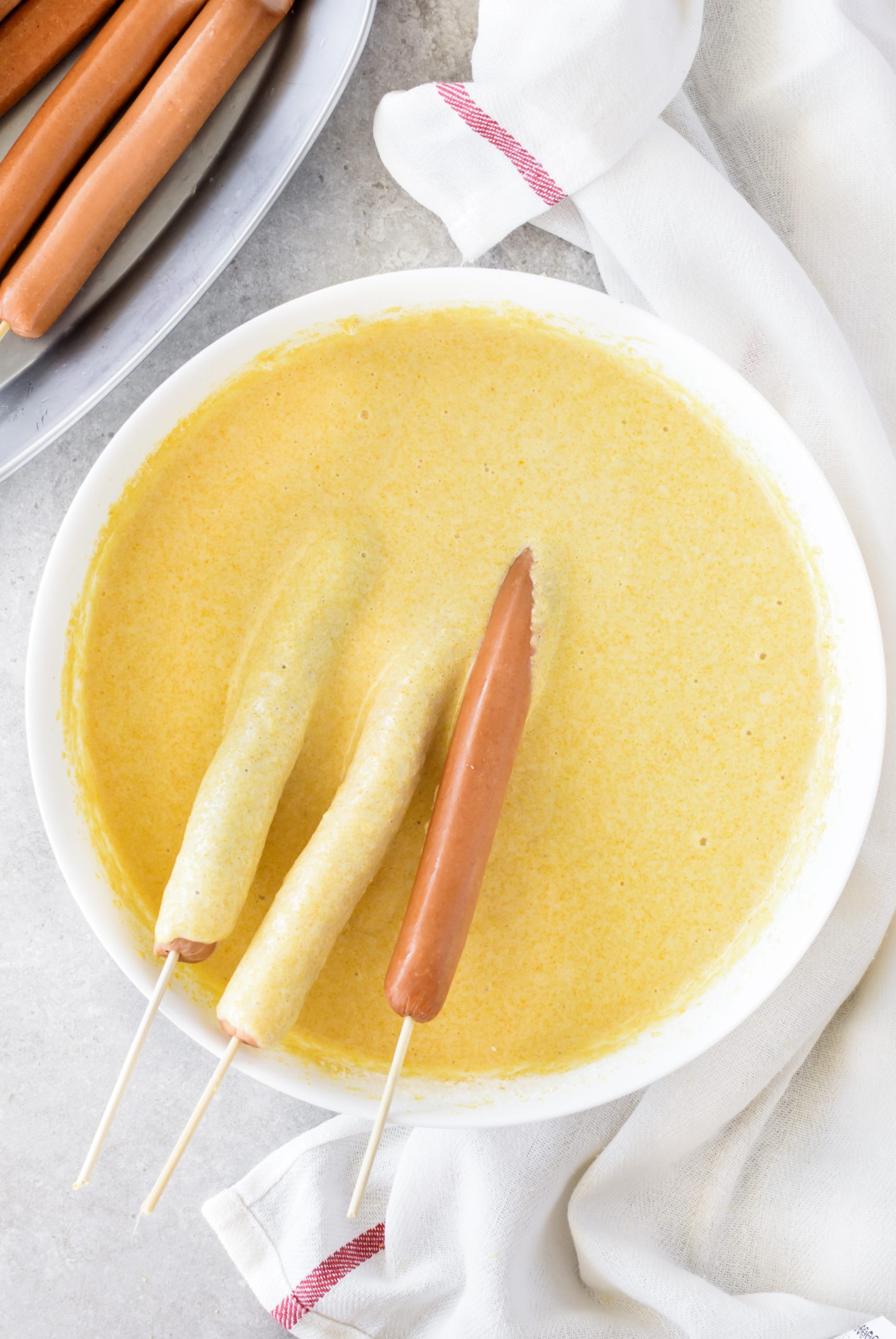 Dip the hot dogs into the batter, and coat them completely.