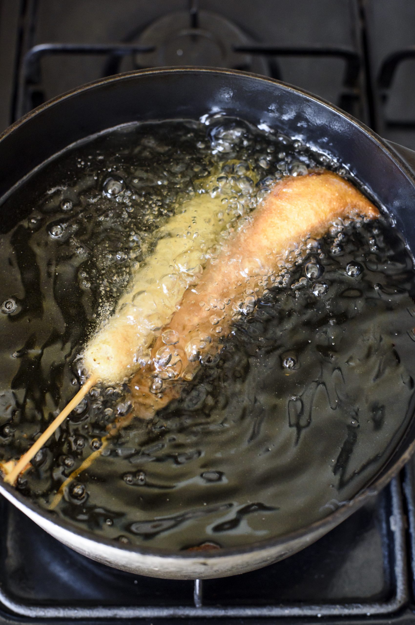 Place the battered corn dogs into the heated oil, and cook for 2-3 minutes until golden brown. 