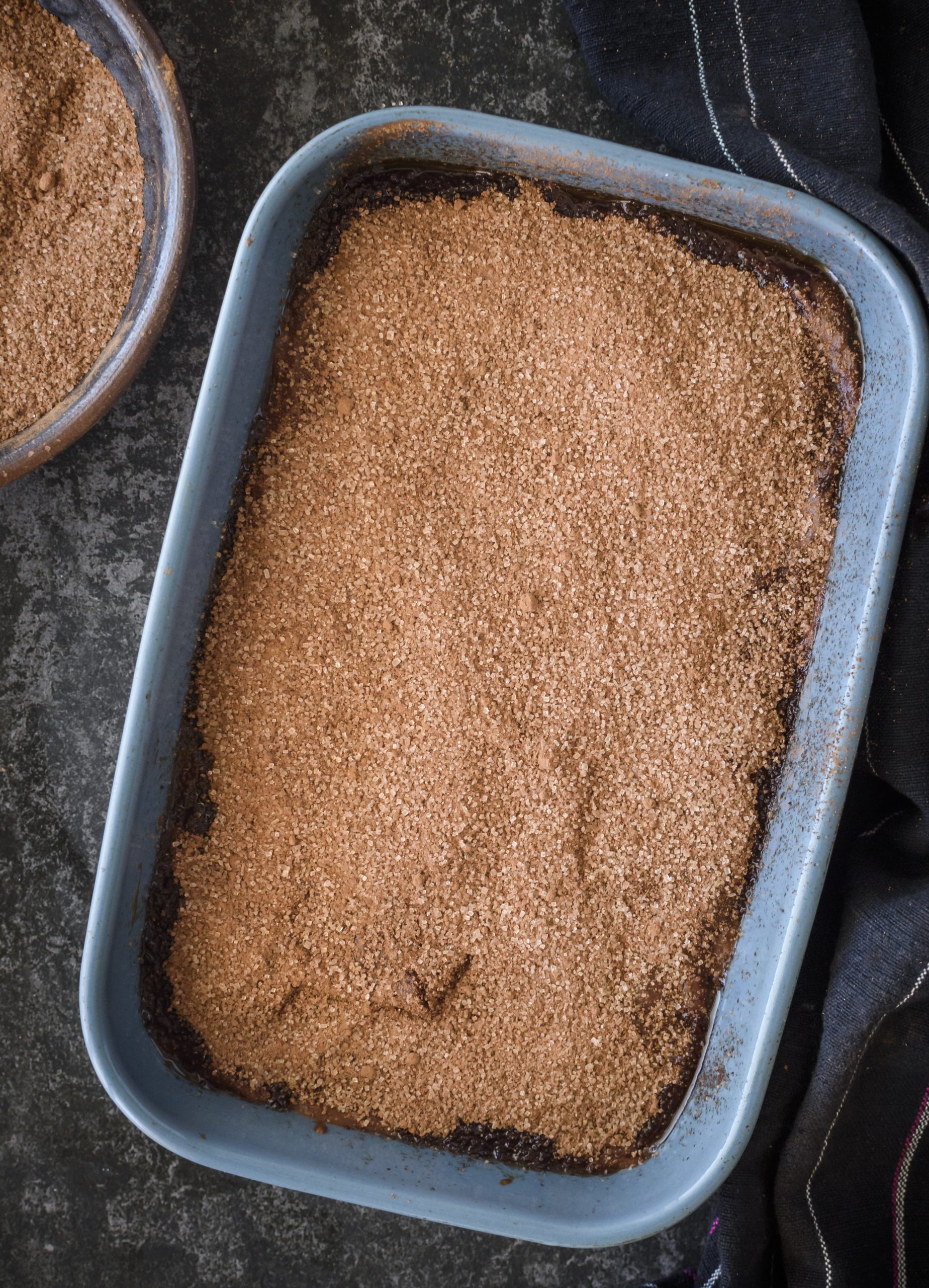 In a bowl, combine the remaining ¼ cup of cocoa powder with the remaining ½ cup of sugar, and sprinkle this mixture over the batter in the baking dish. 