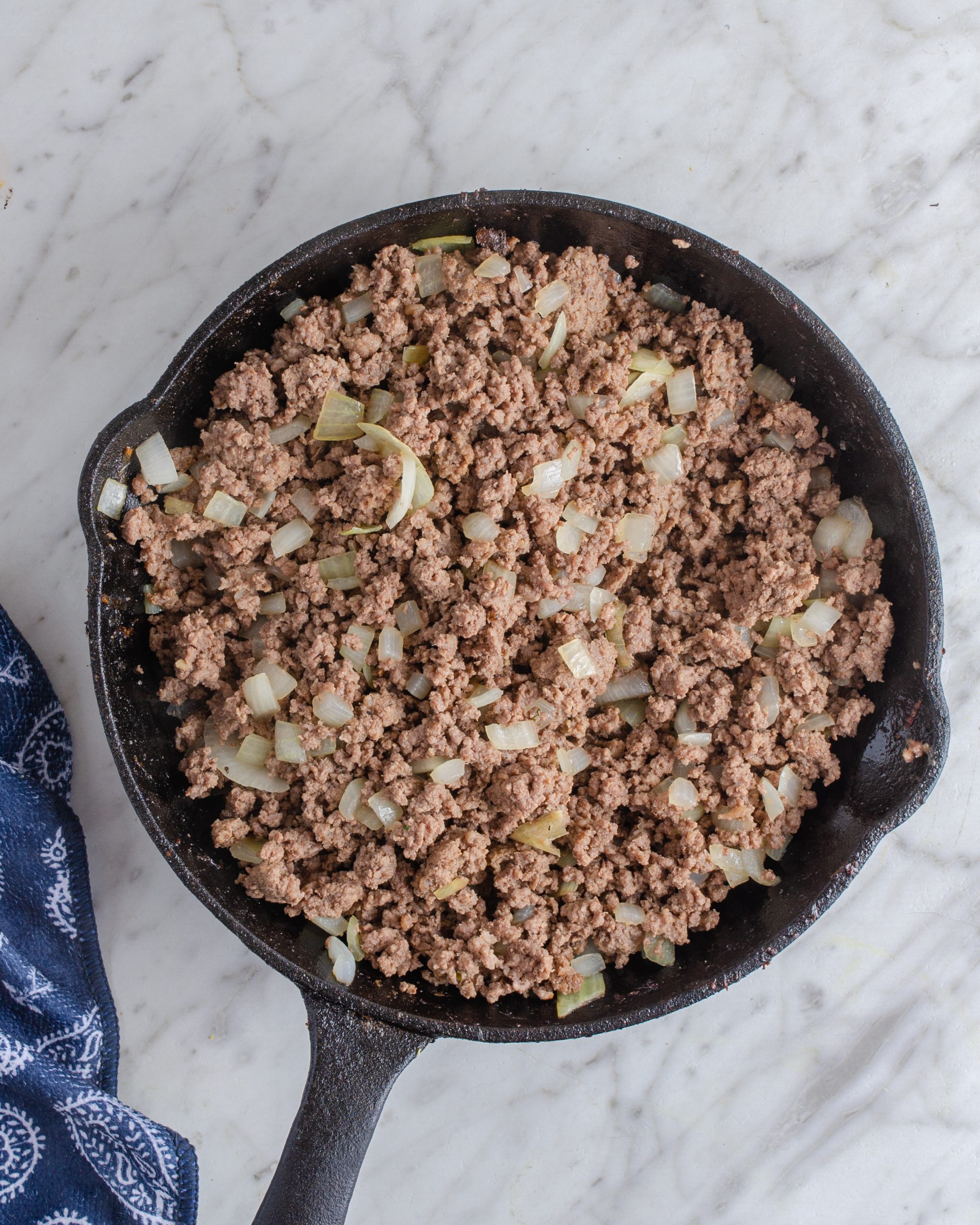 Place the ground beef into a skillet over medium-high heat, and saute until browned completely. Drain any excess grease. 