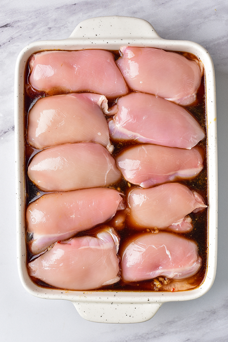 Place ½ of the sauce mixture into a 9x13 baking dish, and add the chicken on top of it. 