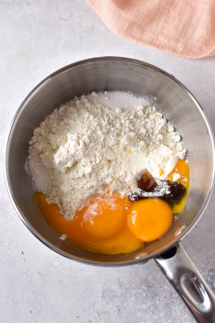 In a bowl, combine the egg yolks, flour, ½ cup sugar, and vanilla extract.