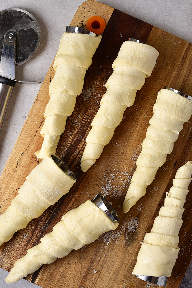 Roll the strips of dough over cone-shaped molds.
