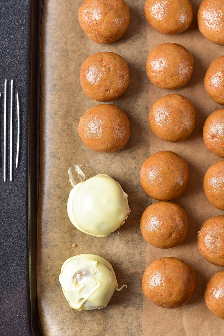 Dip the cake balls into the white chocolate, and place them onto a parchment-lined baking sheet. 