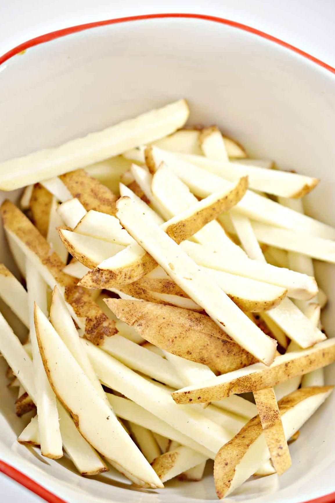 Cut the potatoes into long thin french fry shapes.