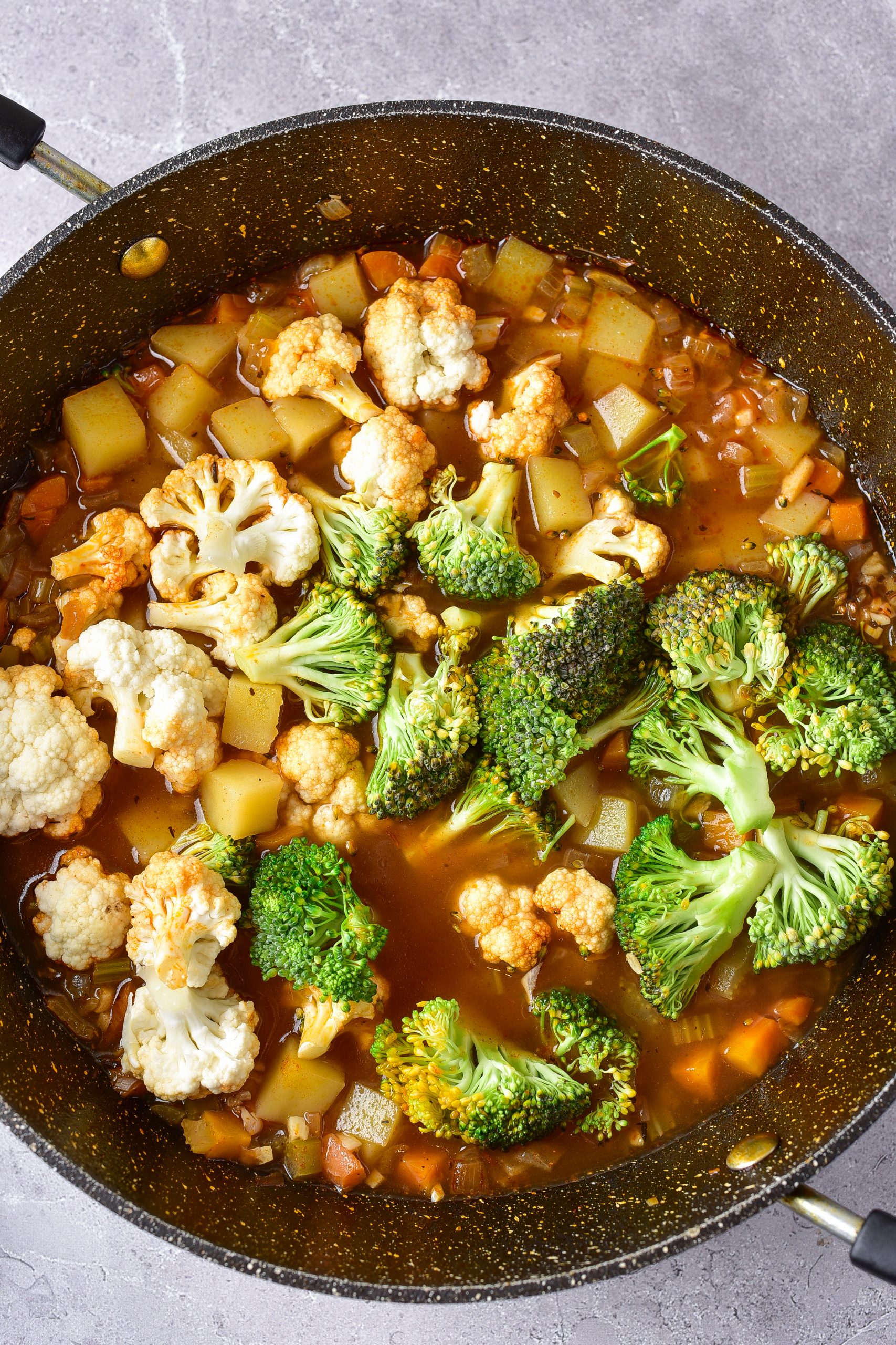 Mix the cauliflower and broccoli florets into the pot, and cook until a crisp-tender. 