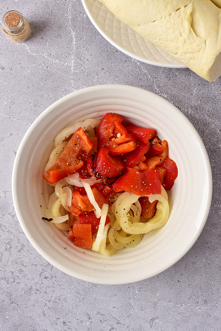 In a bowl, combine the pepperoncini peppers, red peppers, and black pepper. Stir to combine.