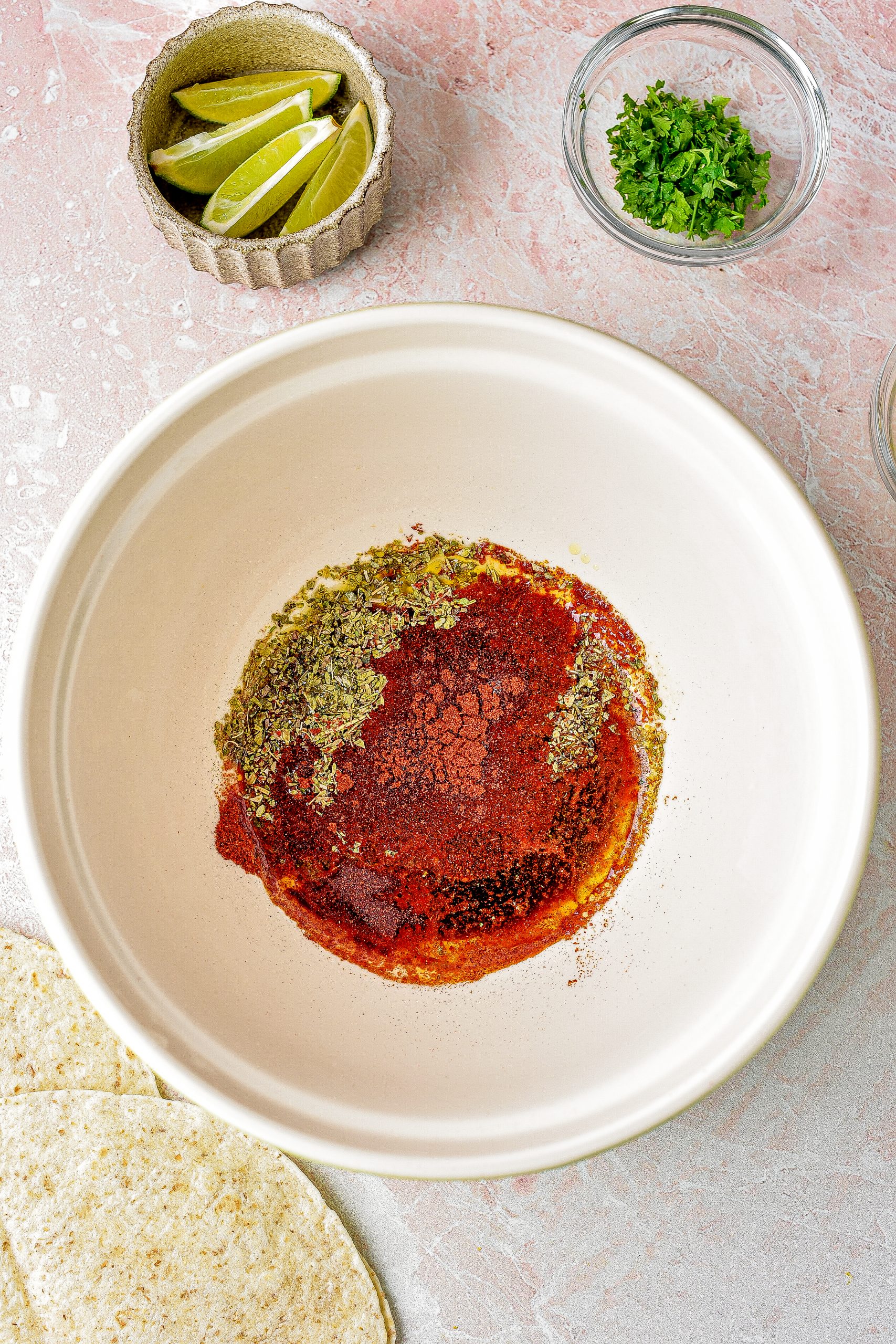 Mix together the oregano, lime juice, cumin, soy sauce, chili powder, and 1 tbsp oil in a bowl. 