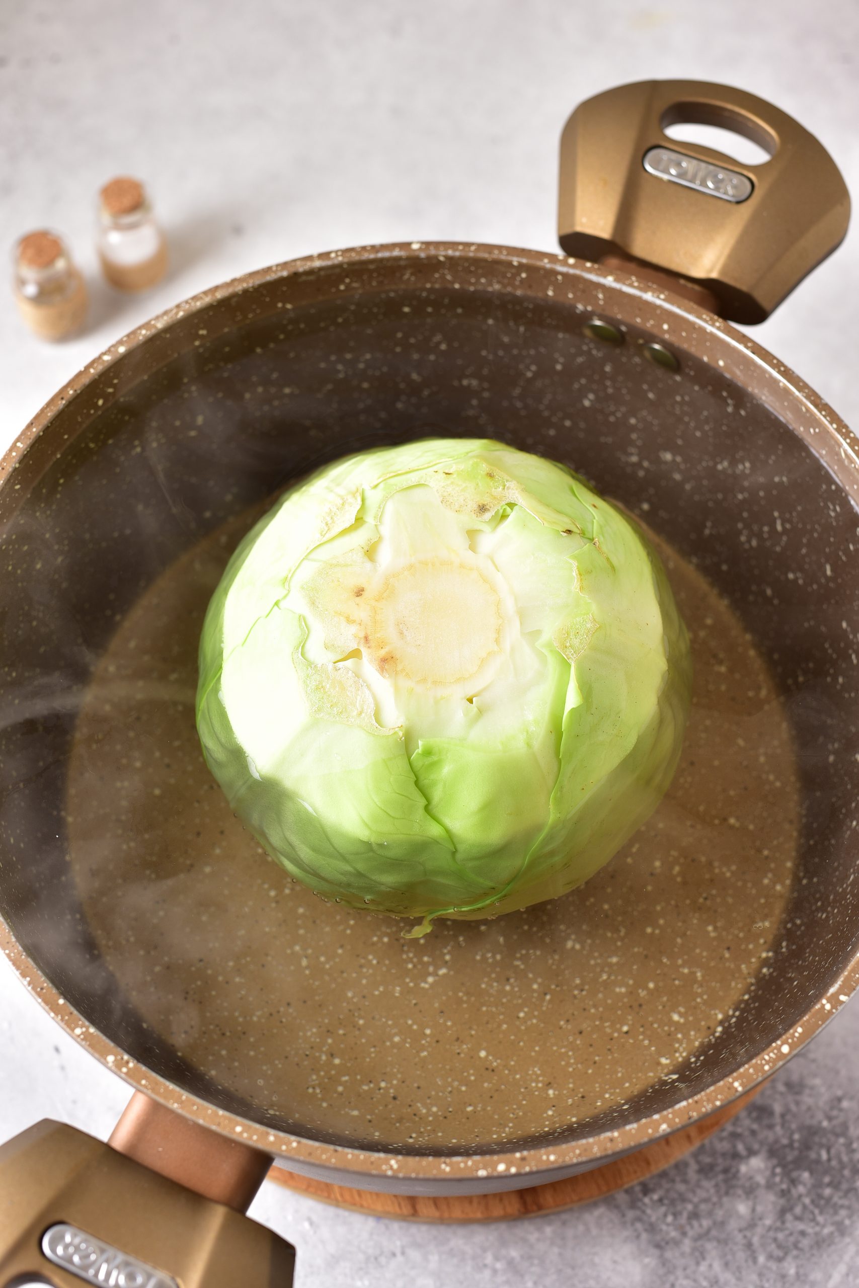 Add the cabbage head to the boiling water, and cook for about 8 minutes, until the leaves are softened a bit. 