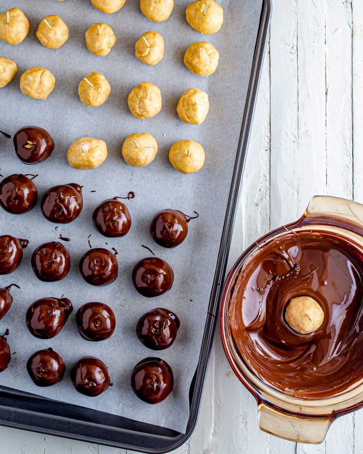 Remove peanut butter balls from the refrigerator. Dip into melted chocolate leaving a small uncovered area so the balls resemble buckeyes. Return to wax paper, the chocolate side down, and remove the toothpick