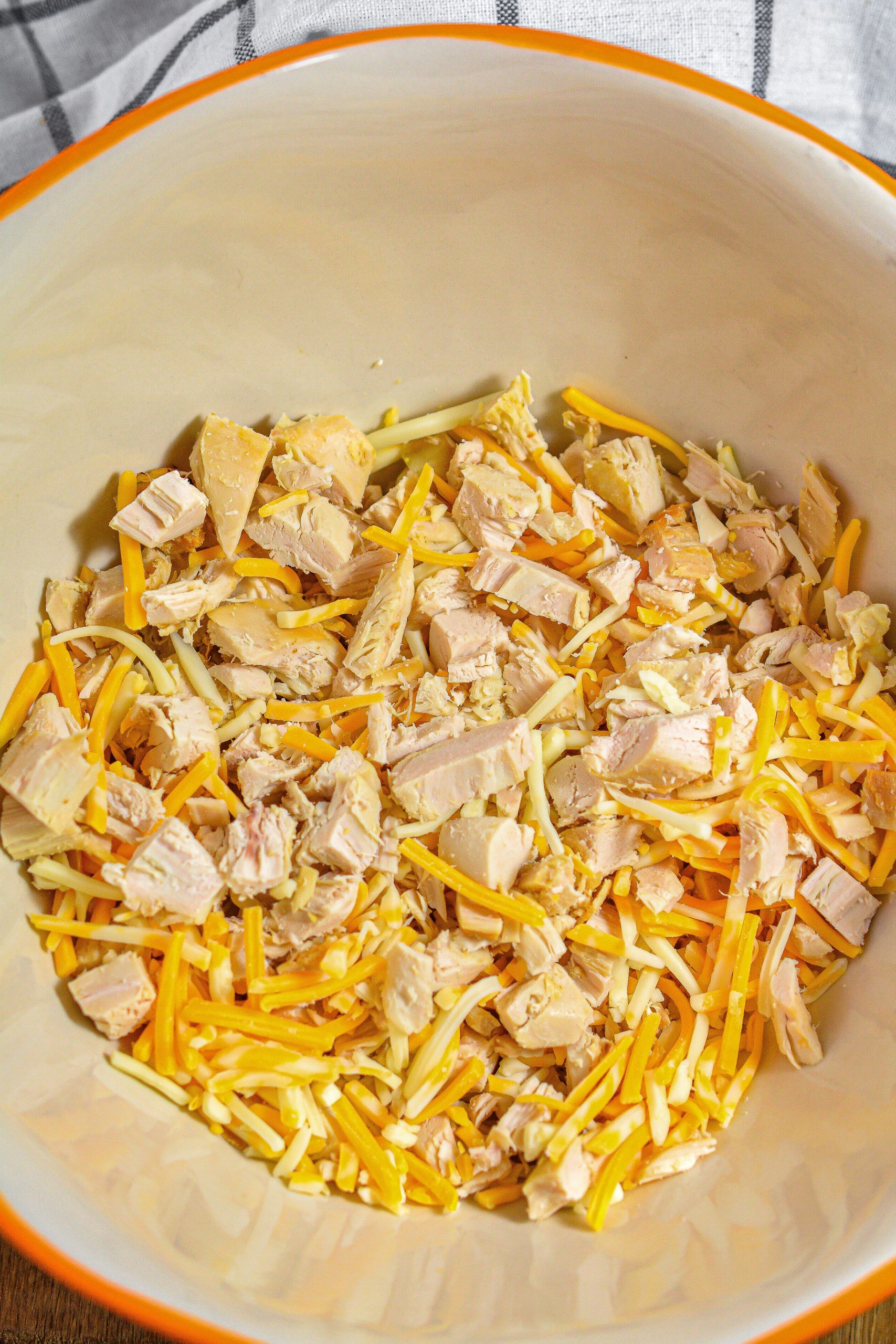 Add the chicken, 1 cup of cheese, and salt and pepper to taste in a mixing bowl
