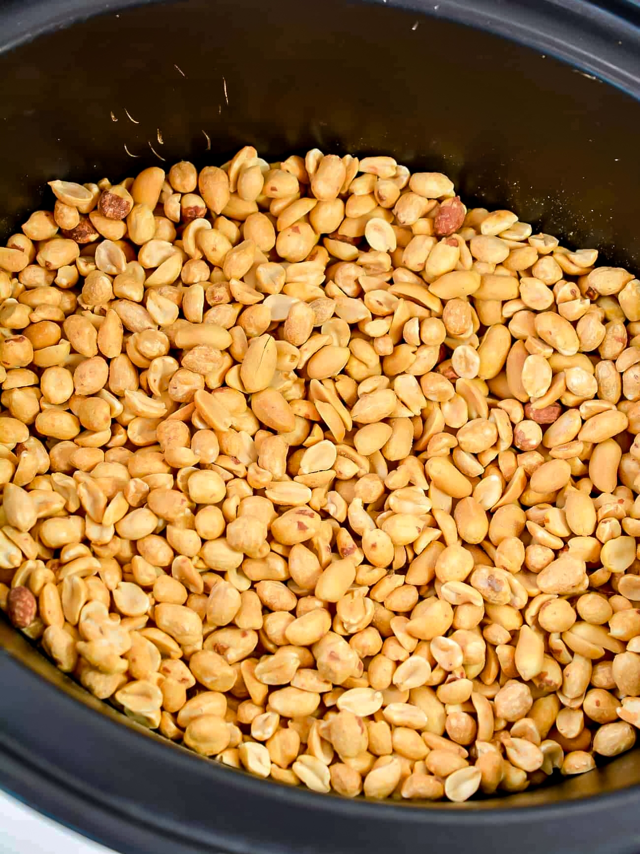 Place the peanuts into the bottom of the slow cooker.