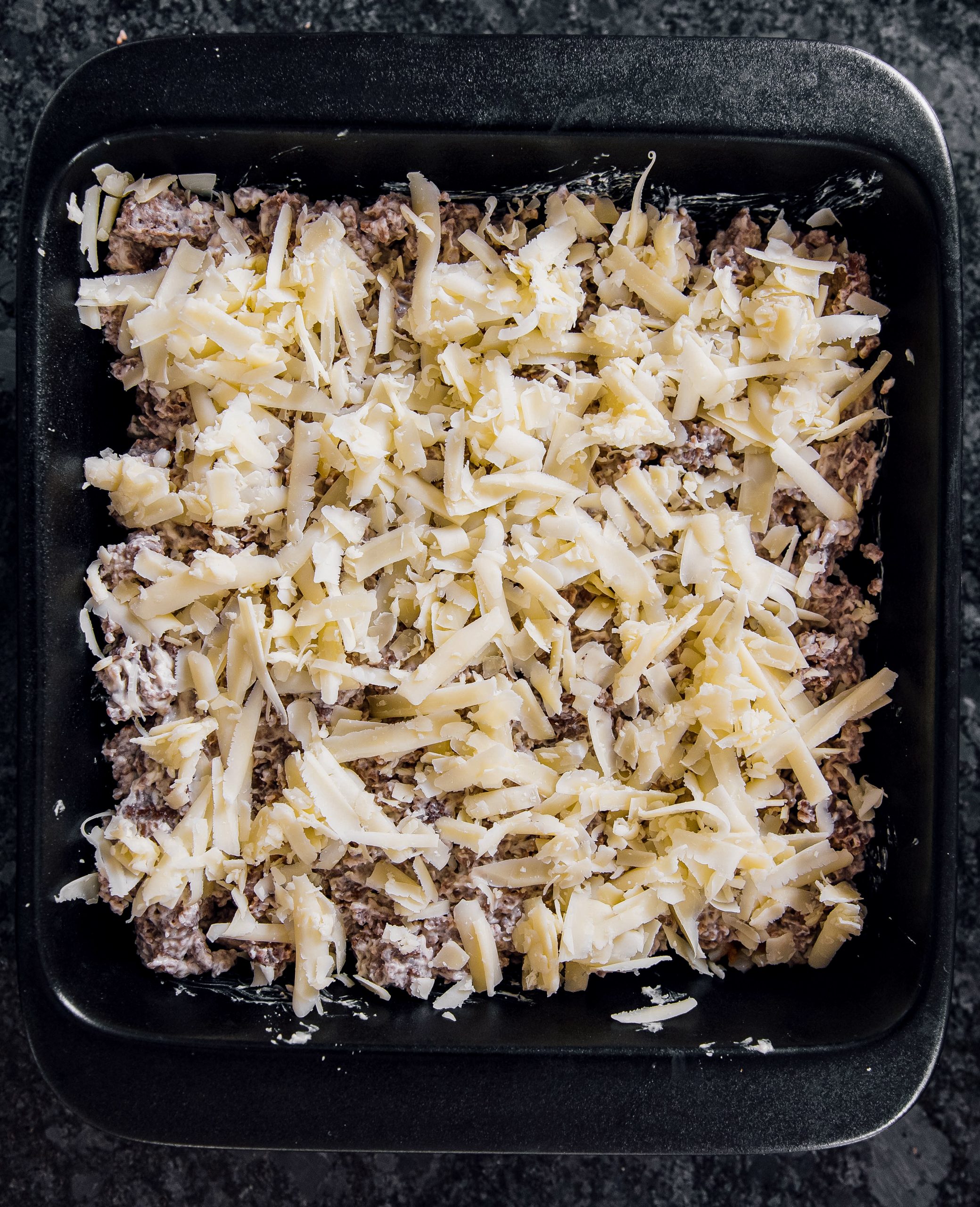 Put the cream cheese and sausage on top of the hash browns, then top with shredded cheese.