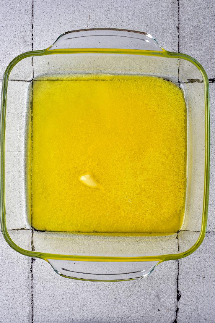 Start by preheating your oven to 350 degrees. In a small bowl, melt butter in the microwave, then pour it into a 9*9 baking dish, making sure it's evenly distributed