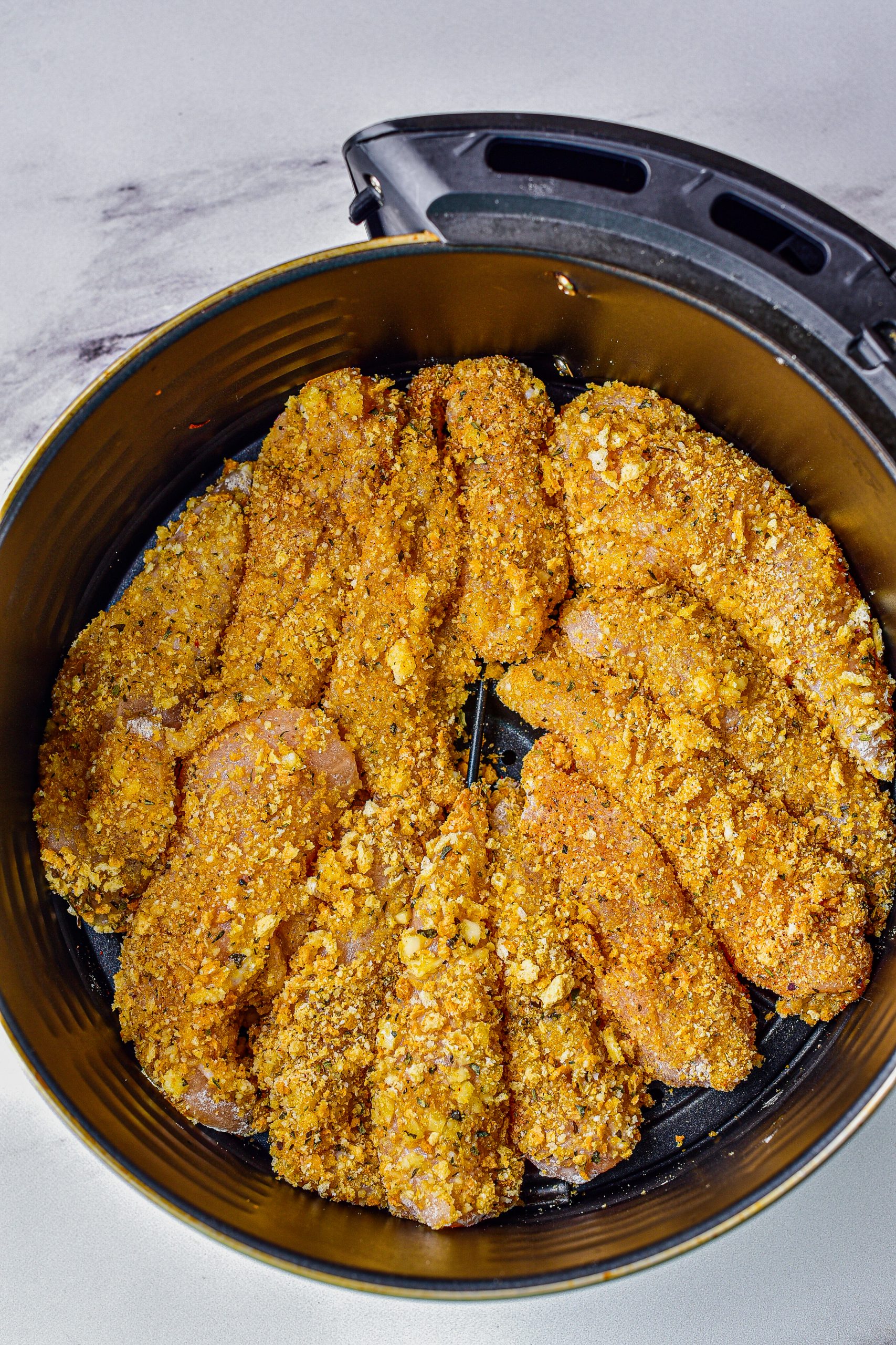 Dredge the chicken tenderloins in the flour mixture, dip them into the olive oil mixture, and coat them in the crumb mixture. 